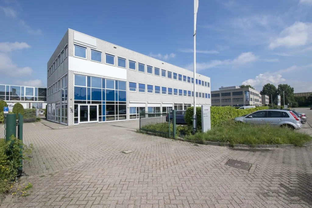 Moderne kantoorgebouw aan de Witboom met glazen gevel en parkeerplaats op de voorgrond.