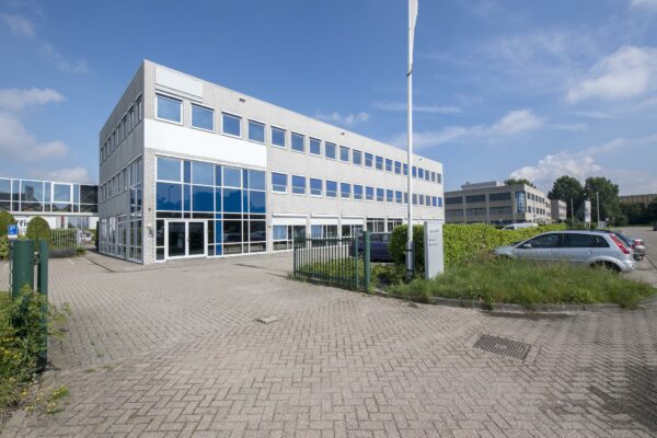 Moderne kantoorgebouw aan de Witboom met glazen gevel en parkeerplaats op de voorgrond.
