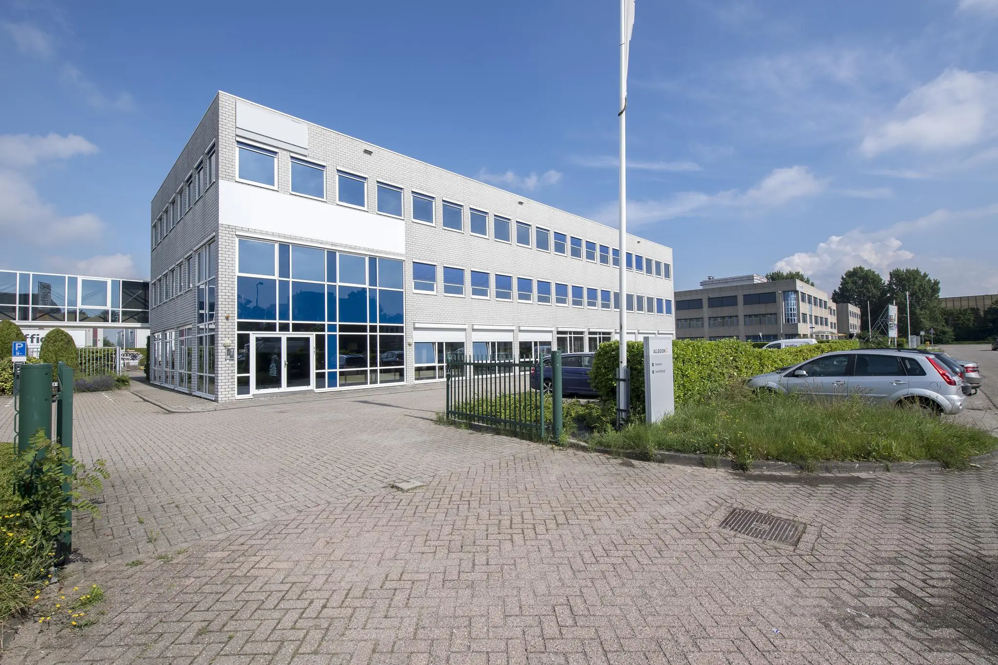 Moderne kantoorgebouw aan de Witboom met glazen gevel en parkeerplaats op de voorgrond.