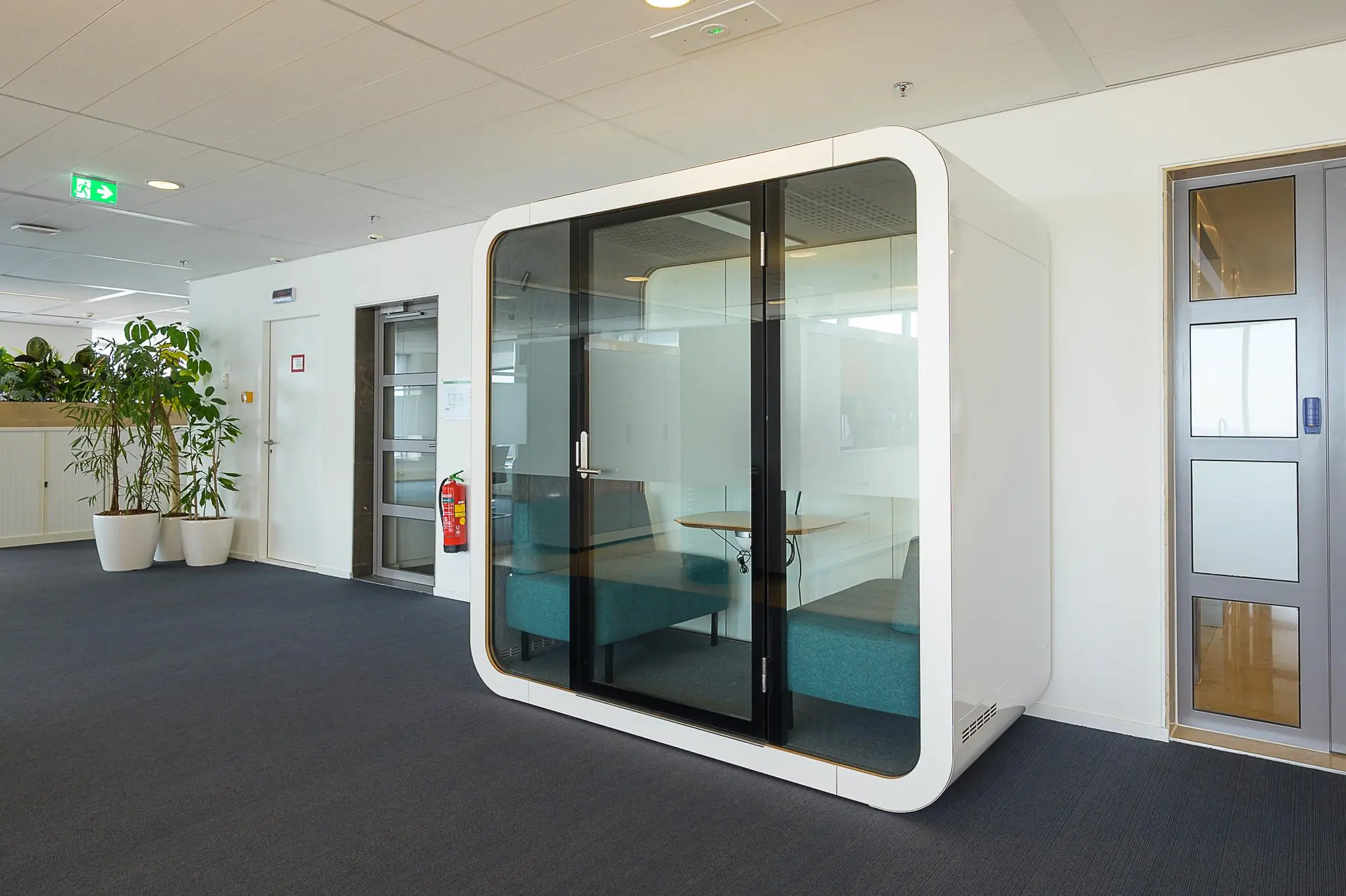 Moderne vergaderpod met glazen wanden en zitbanken in een kantoorruimte aan het Weena.