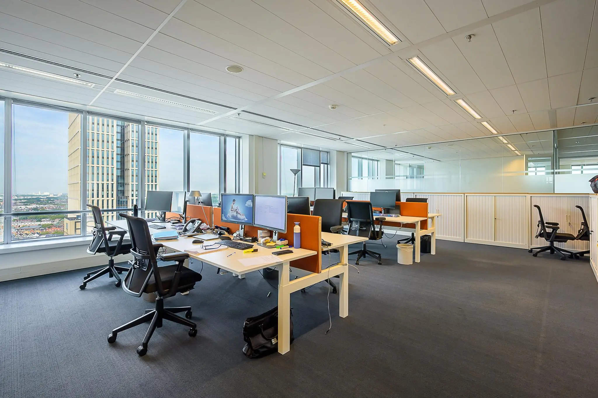 Modern kantoorpand aan het Weena met meerdere bureaus, computers en uitzicht op de stad.