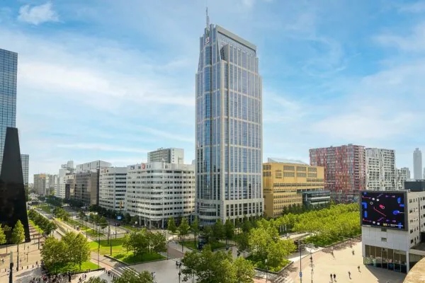Hoog kantoorgebouw aan het Weena in Rotterdam met omliggende moderne architectuur en groene stadsomgeving.
