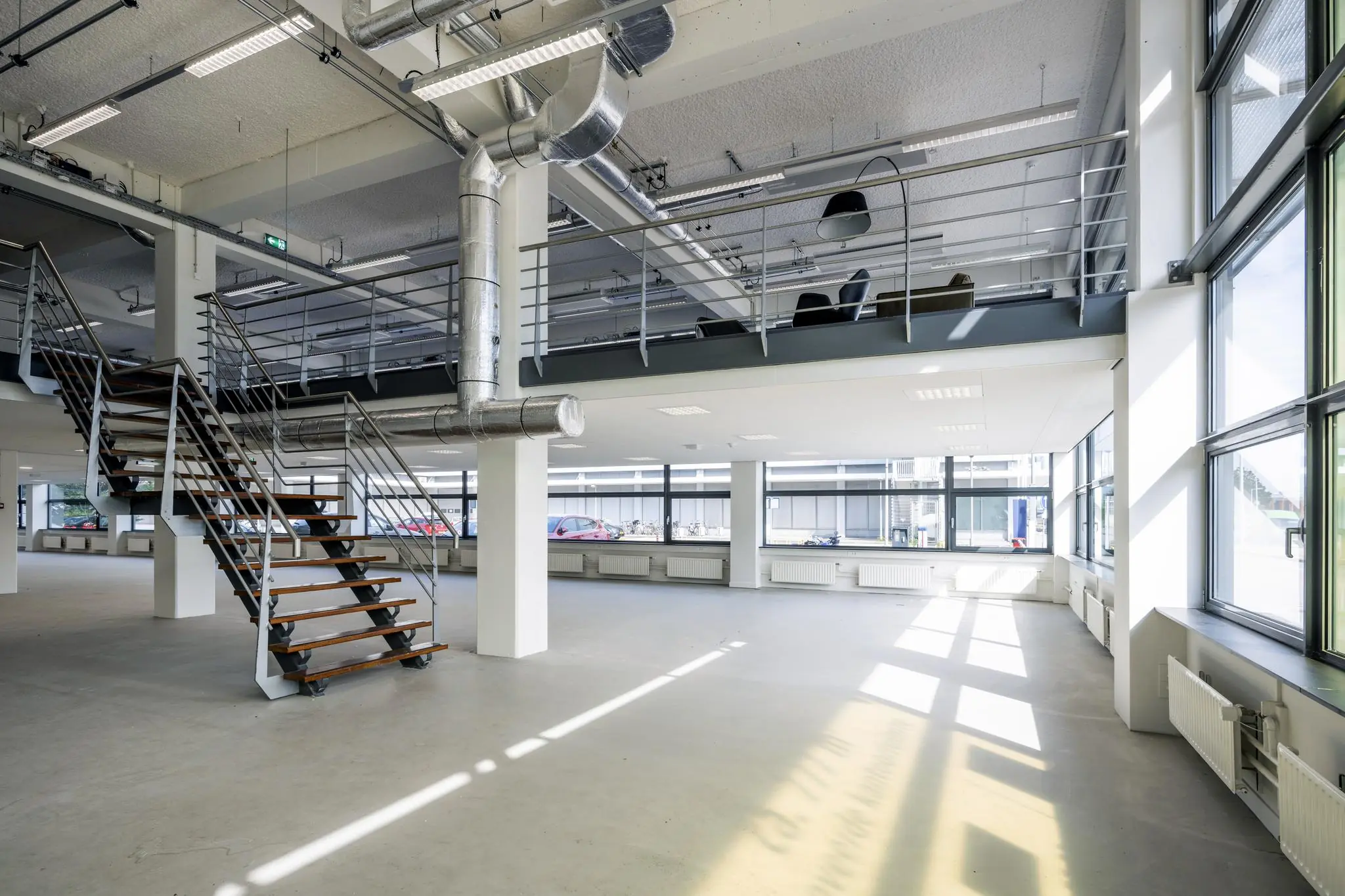 Licht en modern kantoorpand aan de Kabelweg met industriële afwerking en een open trap naar de entresol.