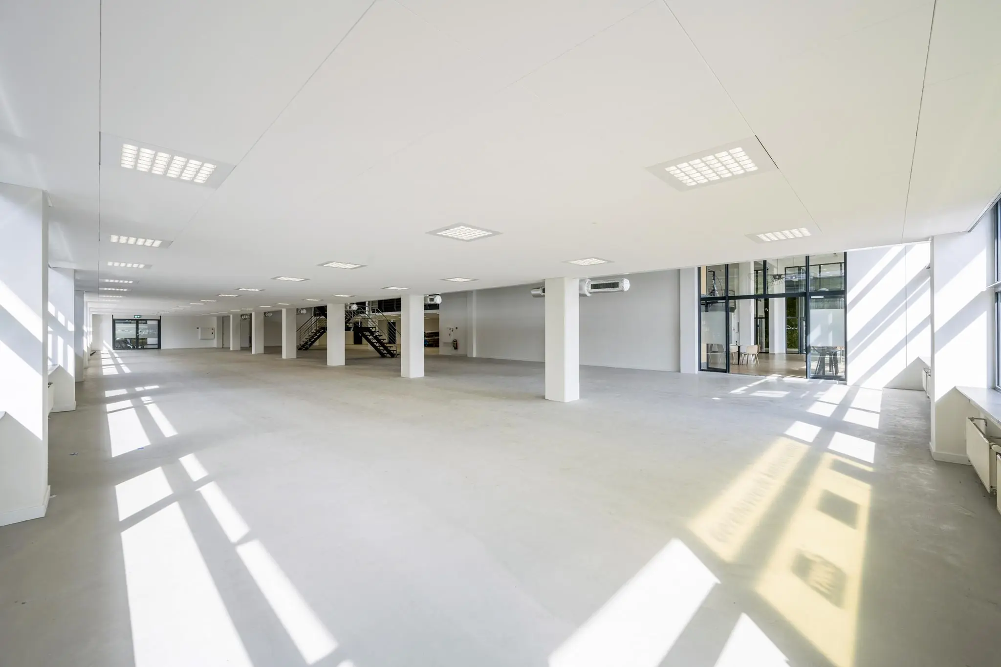 Ruime, lichte en lege kantoorruimte aan de Kabelweg met grote ramen en moderne afwerking.