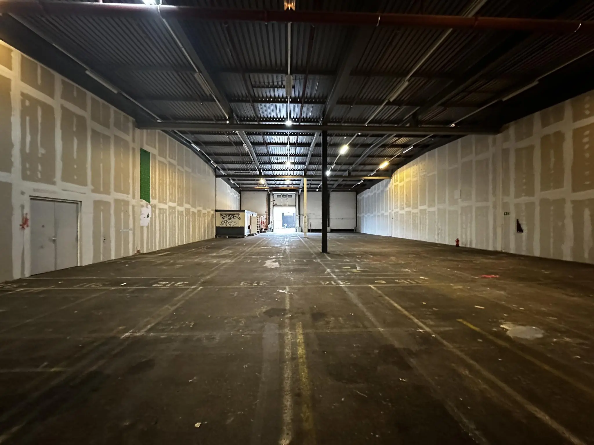 Lege industriële loods aan de Locomotiefstraat met betonnen vloer en onafgewerkte wanden.