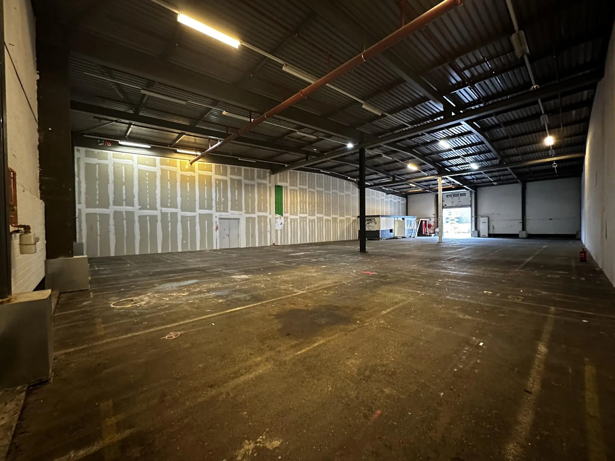 Leeg magazijn aan de Locomotiefstraat met hoge plafonds en betonnen vloer.