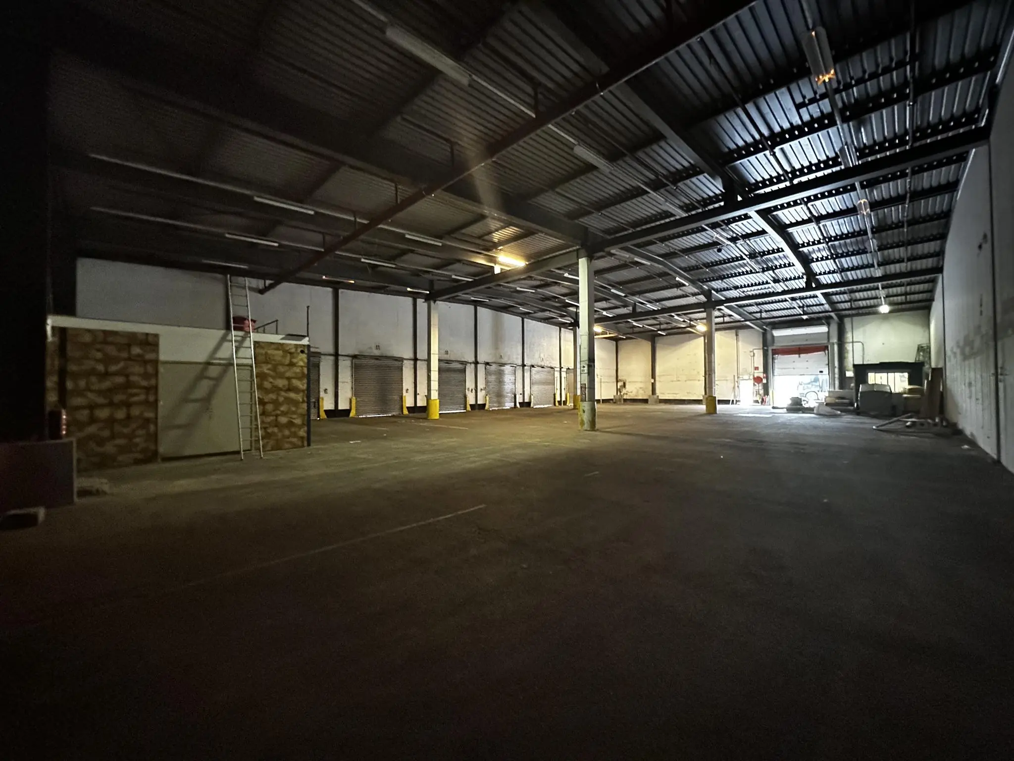 Lege industriële loods aan de Locomotiefstraat met open laadperrons en stalen dakconstructie.