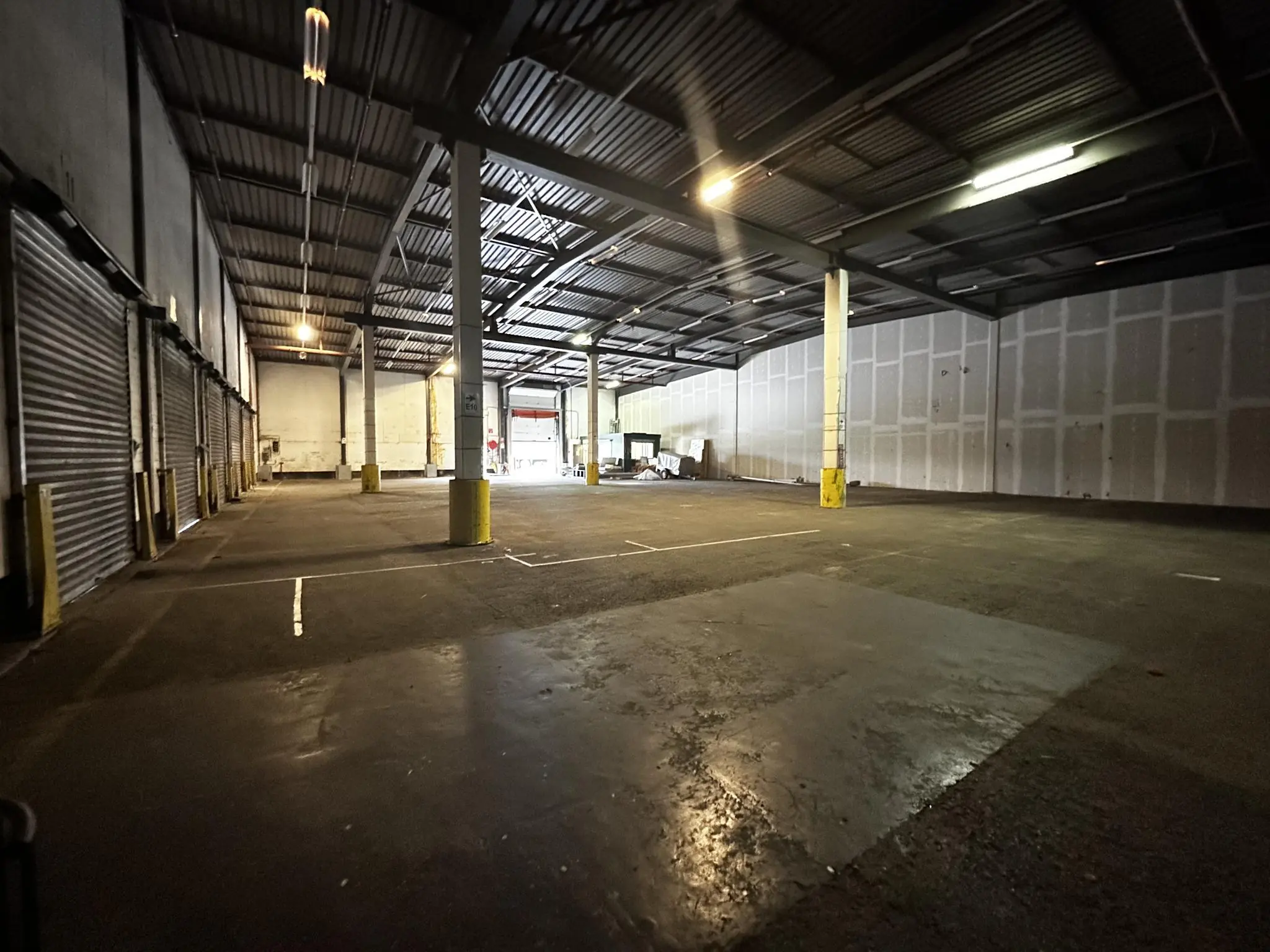 Ruime, lege bedrijfsloods aan de Locomotiefstraat met betonnen vloer en stalen dakconstructie.