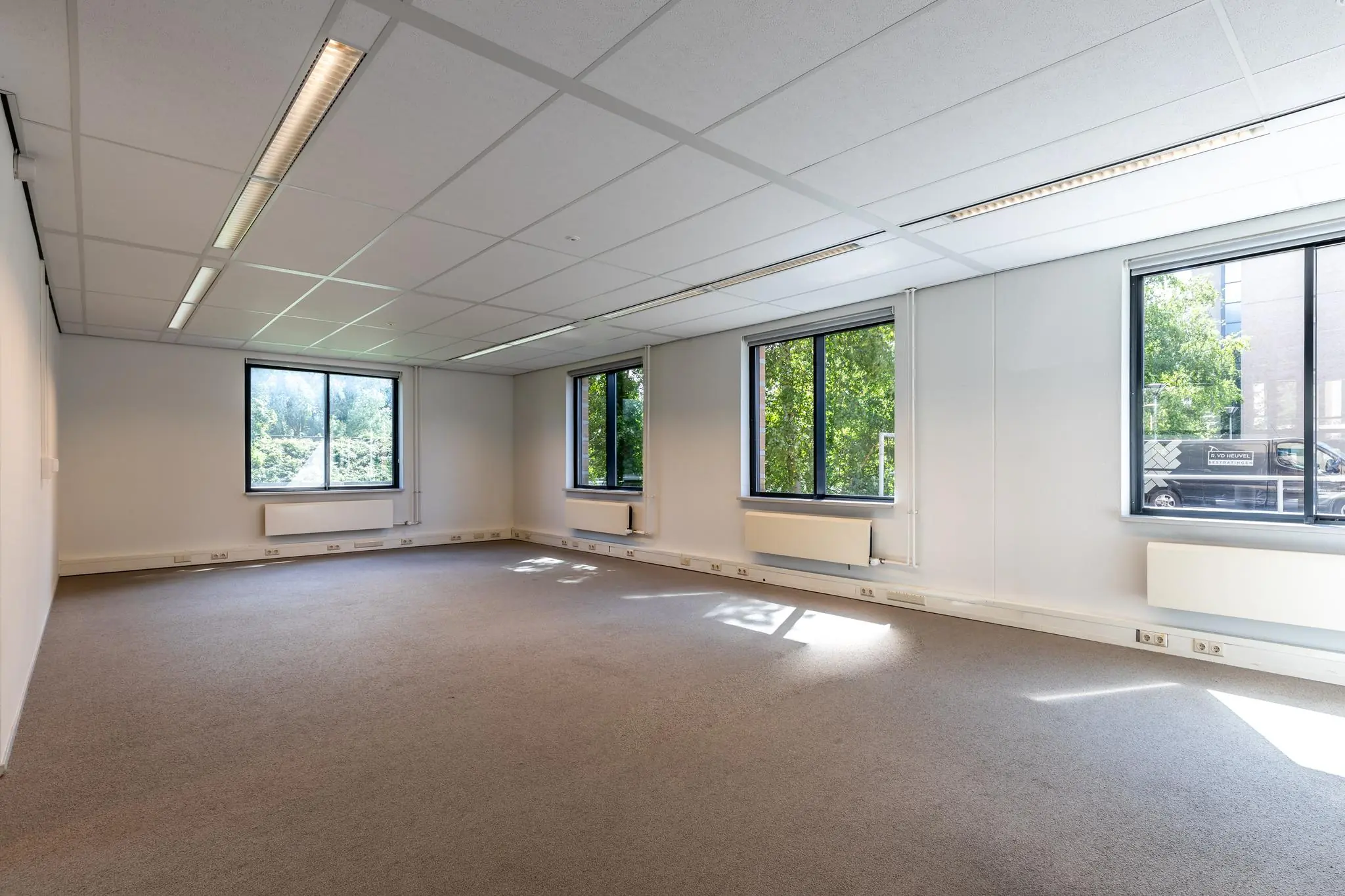 Lichte, lege kantoorruimte aan de Euclideslaan met grote ramen en systeemplafond.