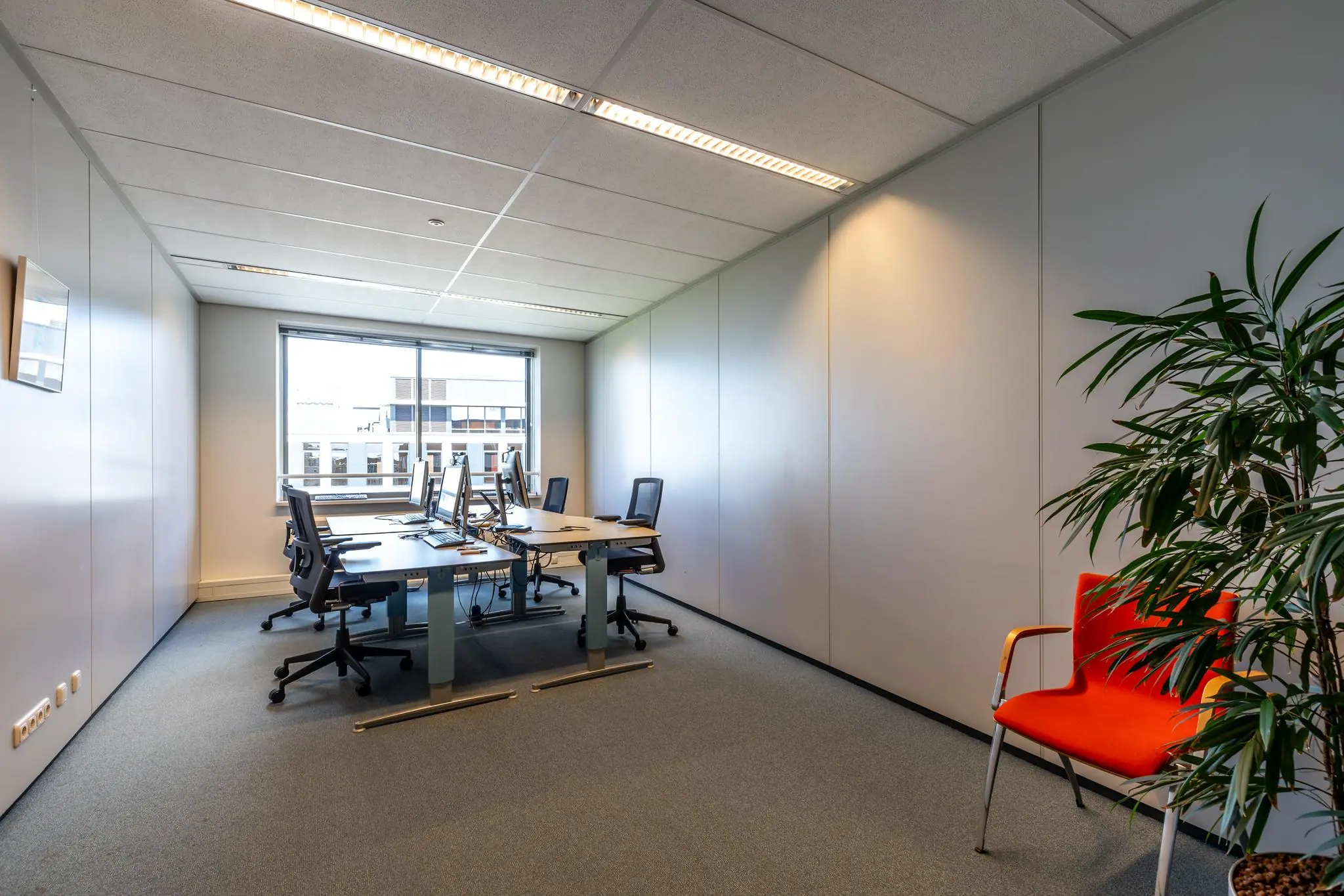 Moderne kantoorruimte aan de Euclideslaan met bureaus, computers, ergonomische stoelen en een groot raam met daglicht.