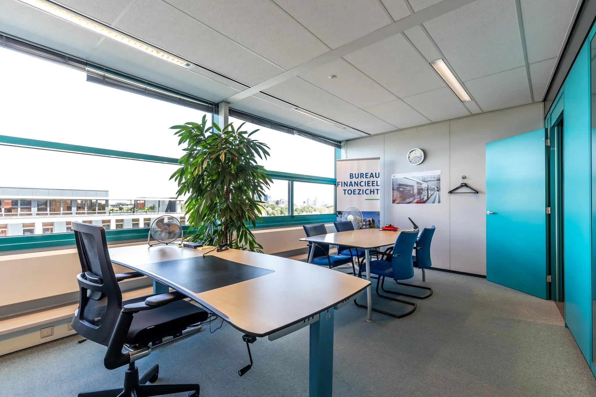 Modern kantoor met bureau, vergadertafel en banner van Bureau Financieel Toezicht aan de Euclideslaan.