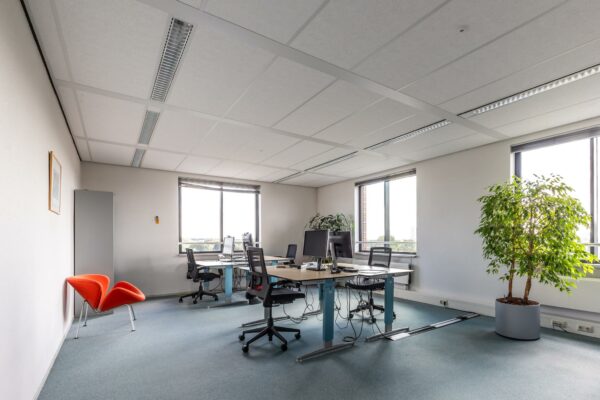 Modern kantoor met meerdere werkplekken, grote ramen en groene planten aan de Euclideslaan.