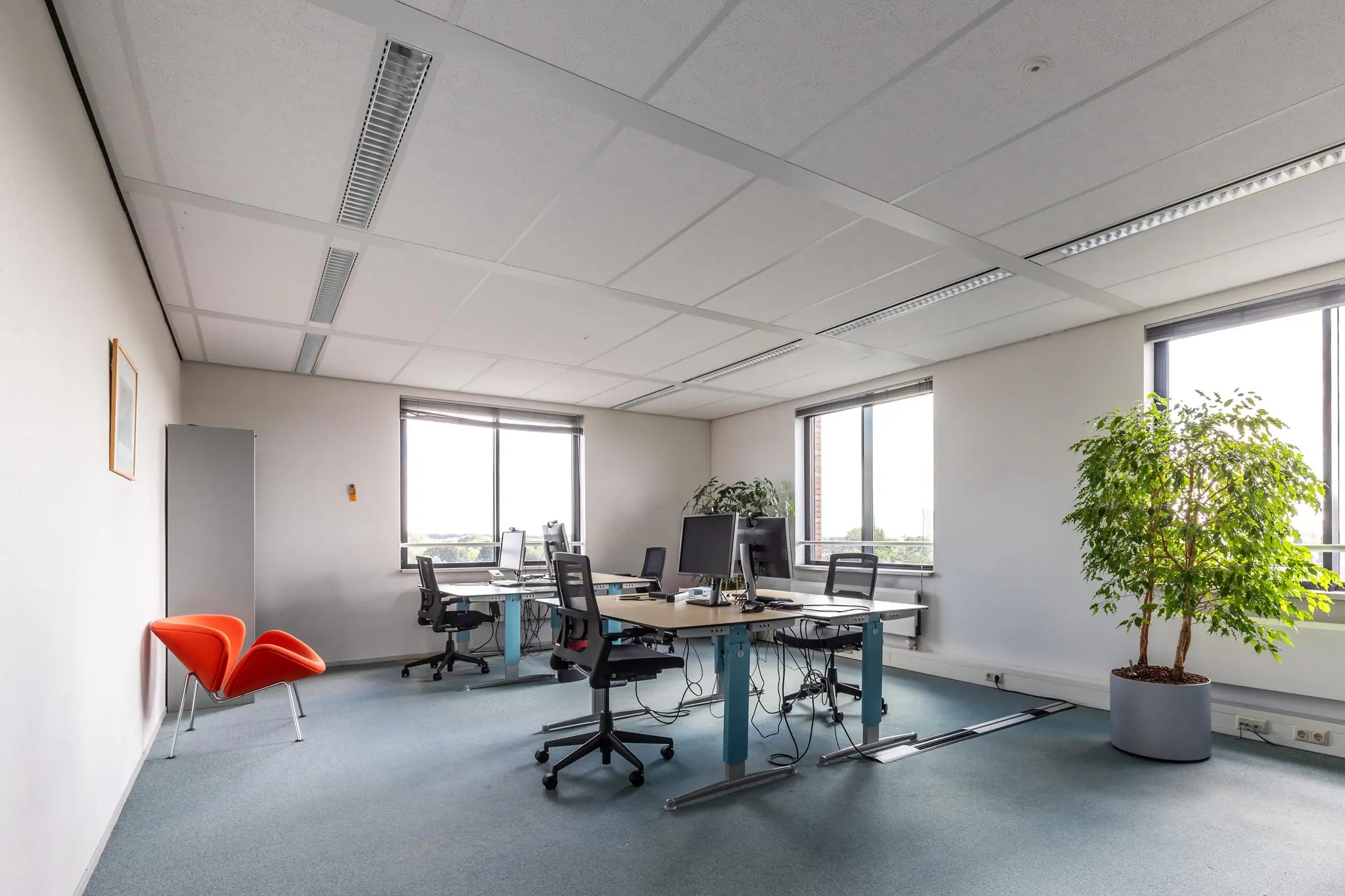 Modern kantoor met meerdere werkplekken, grote ramen en groene planten aan de Euclideslaan.