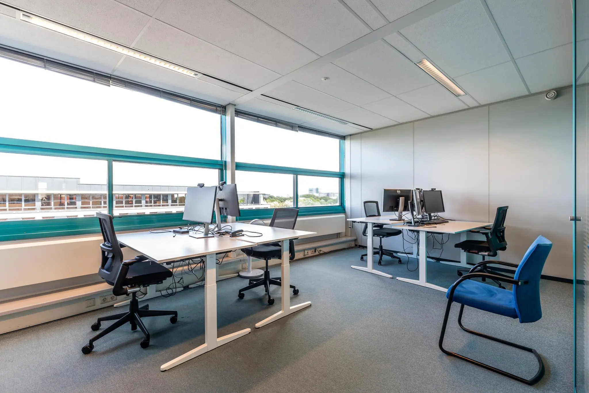 Modern kantoor met vier werkplekken, bureaustoelen en grote ramen aan de Euclideslaan.