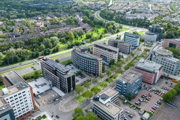 Luchtfoto van kantoorgebouwen aan de Euclideslaan in Utrecht, omgeven door woonwijken, groen en een snelweg.
