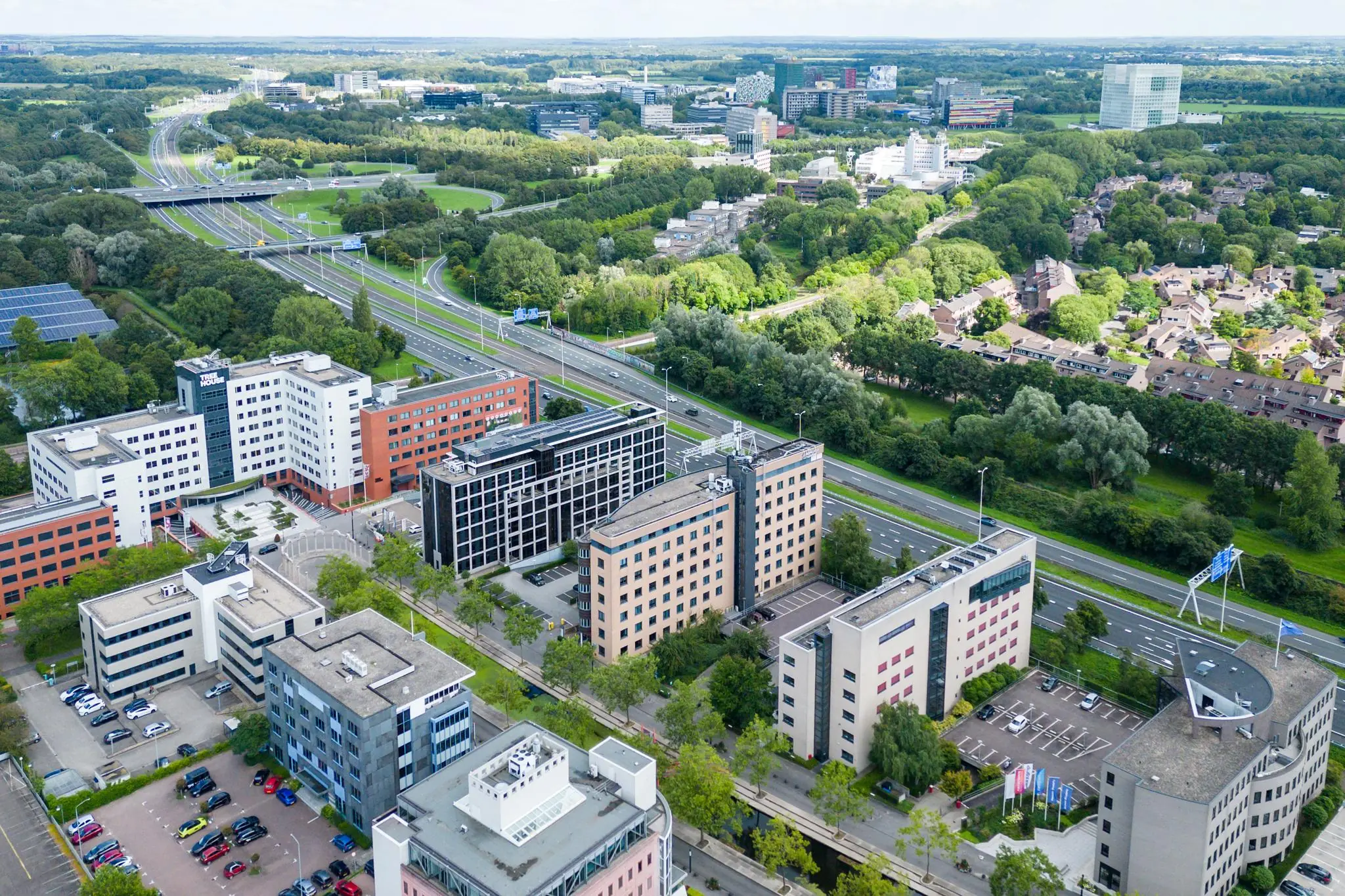 Luchtfoto van kantoren en gebouwen aan de Euclideslaan in Utrecht, grenzend aan snelwegen en groene woonwijken.