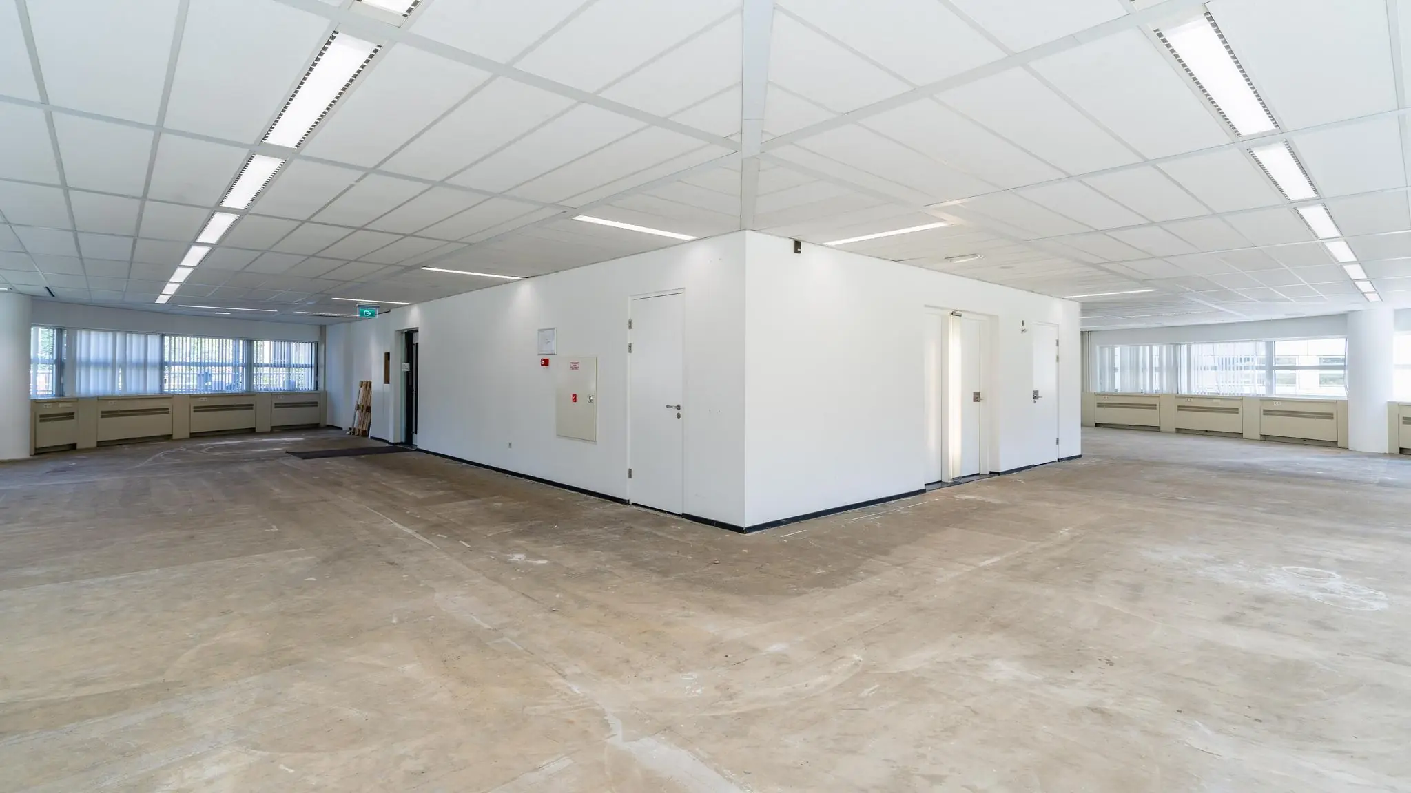 Leeg kantoorpand op het Churchillplein met systeemplafond, kale vloer en witte binnenwanden.