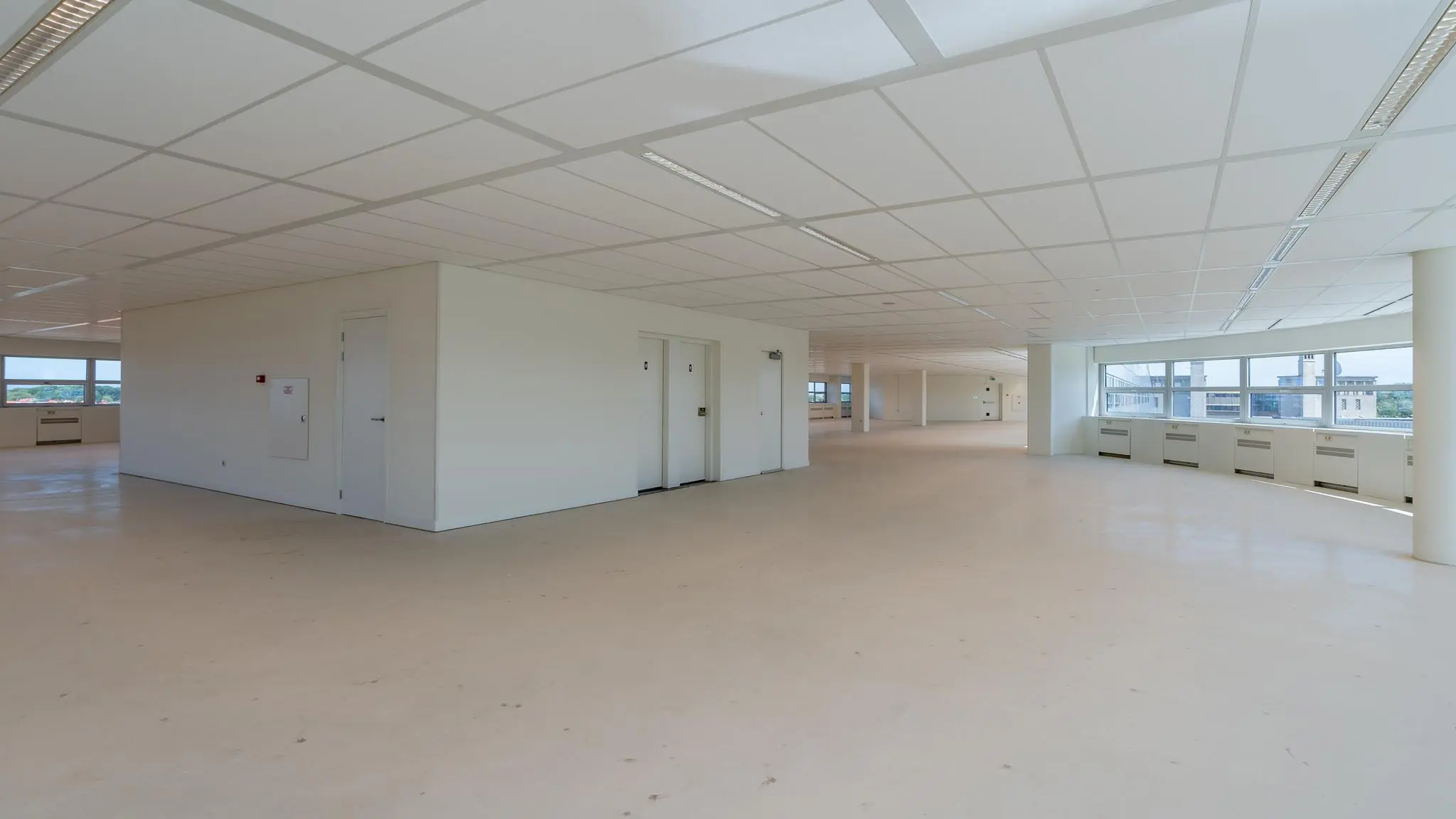 Lichte, lege kantooretage met systeemplafond en grote ramen aan het Churchillplein.