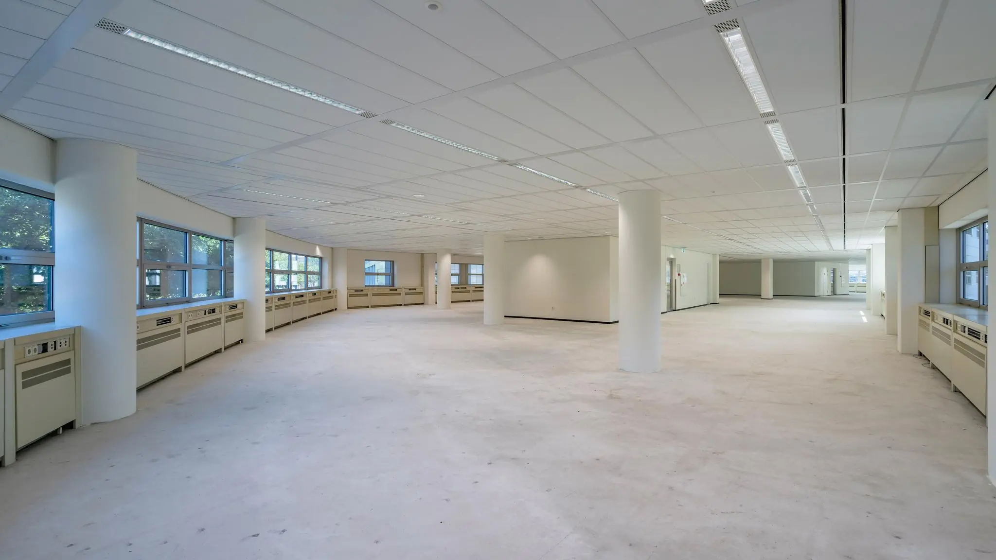 Ruime, lege kantoorruimte met grote ramen aan het Churchillplein.