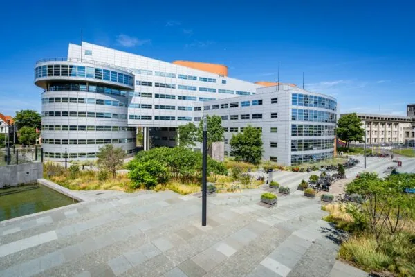 Modern kantoorgebouw aan het Churchillplein in Den Haag, omgeven door groen en fietsenstallingen.