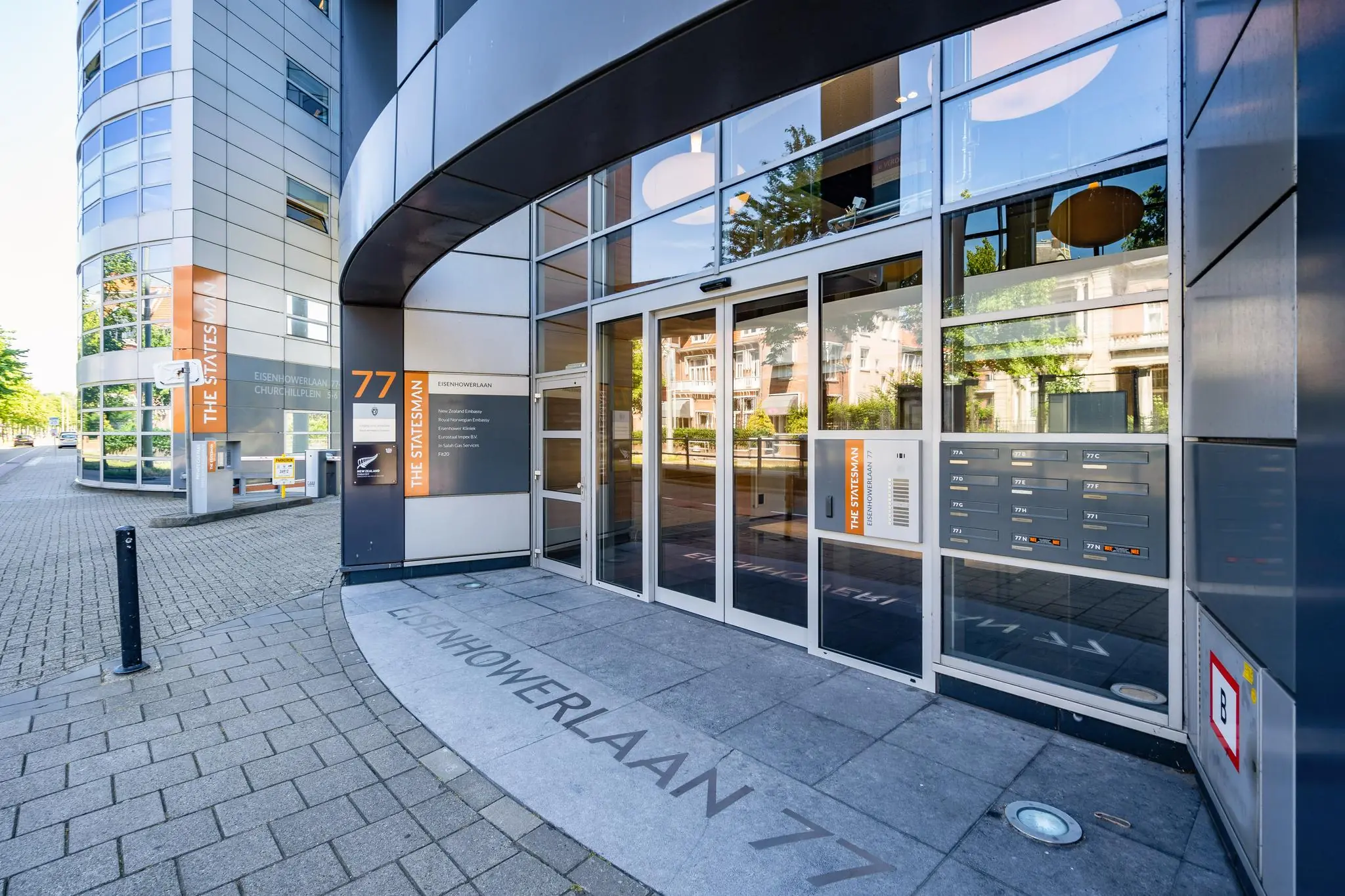 Ingang van het kantoorgebouw 'The Statesman' aan de Eisenhowerlaan 77 op de hoek met het Churchillplein.