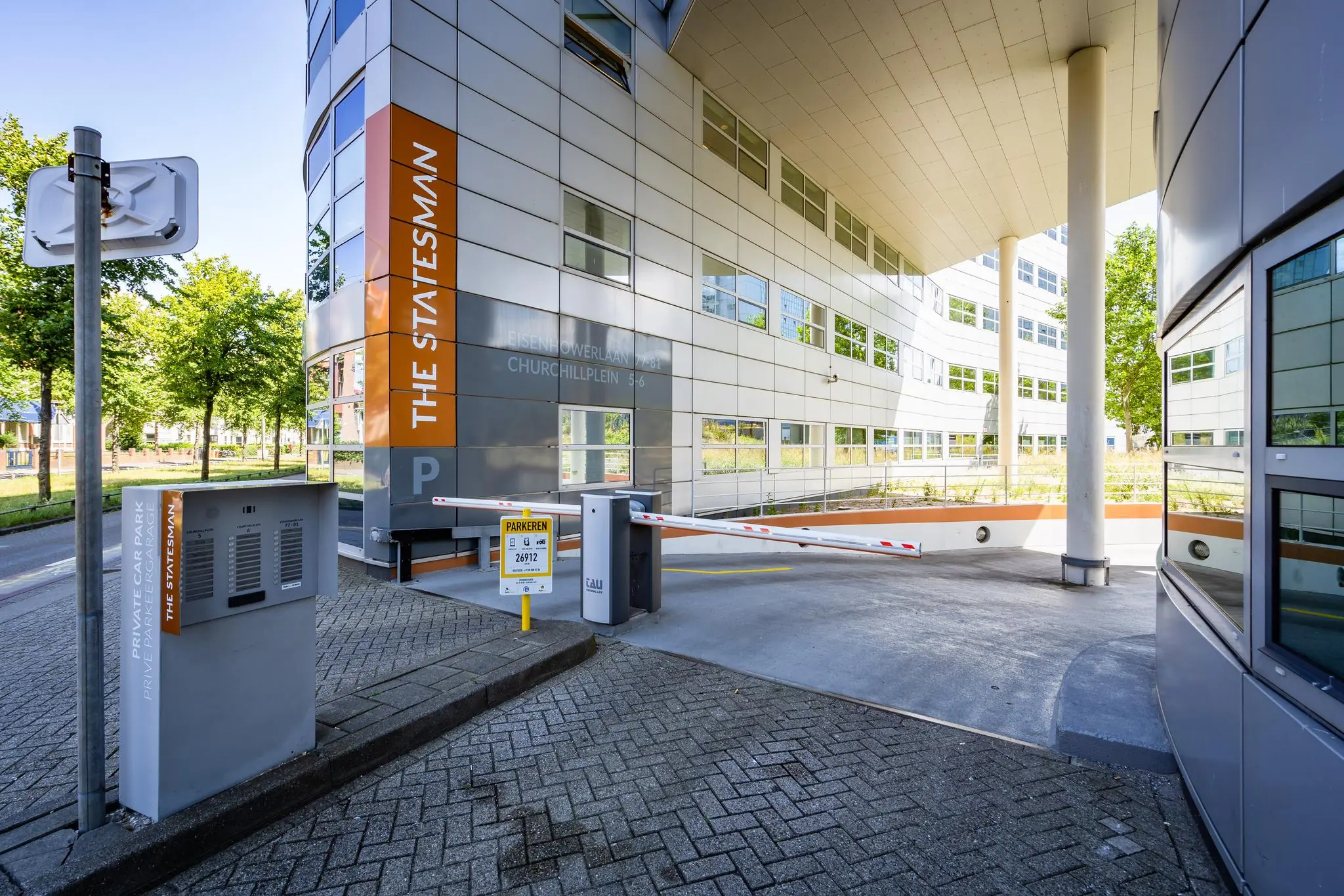Ingang van de privéparkeergarage bij The Statesman aan het Churchillplein in een modern kantoorgebouw.