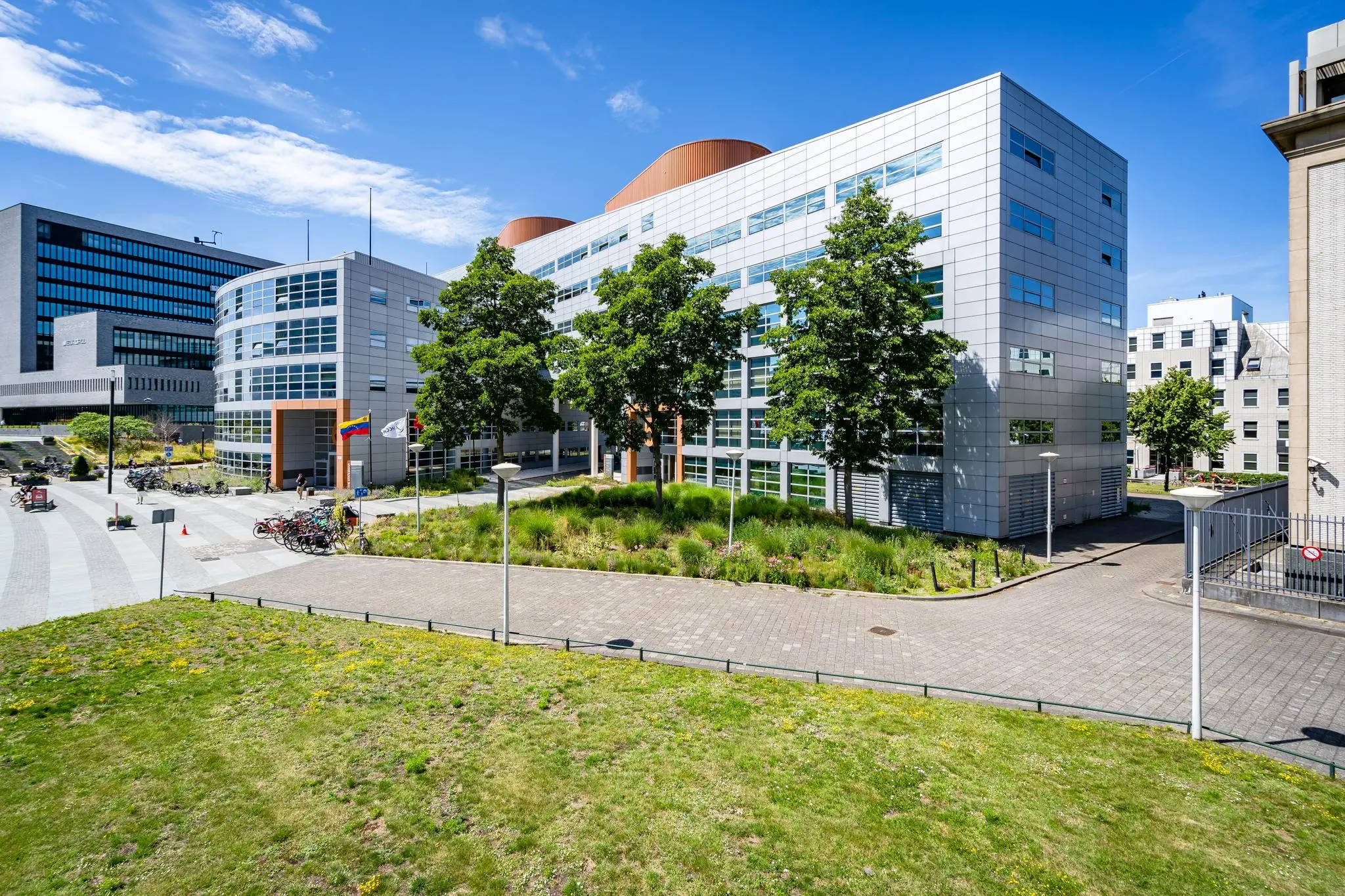 Modern kantoorgebouw aan het Churchillplein in Den Haag met omliggend groen en fietsenstalling.