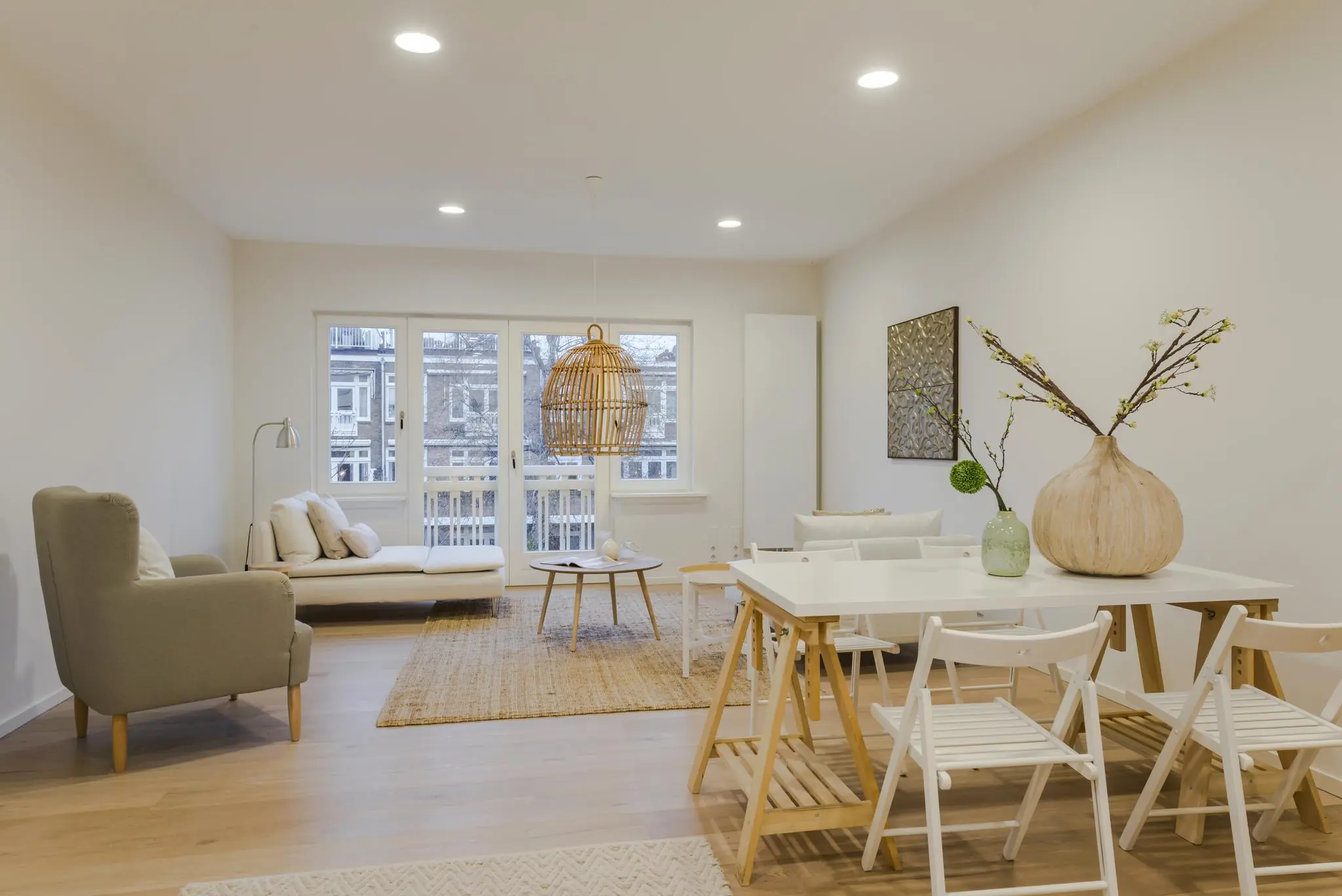 Modern ingerichte woonkamer met houten vloer, licht meubilair en uitzicht op het Concertgebouwplein.