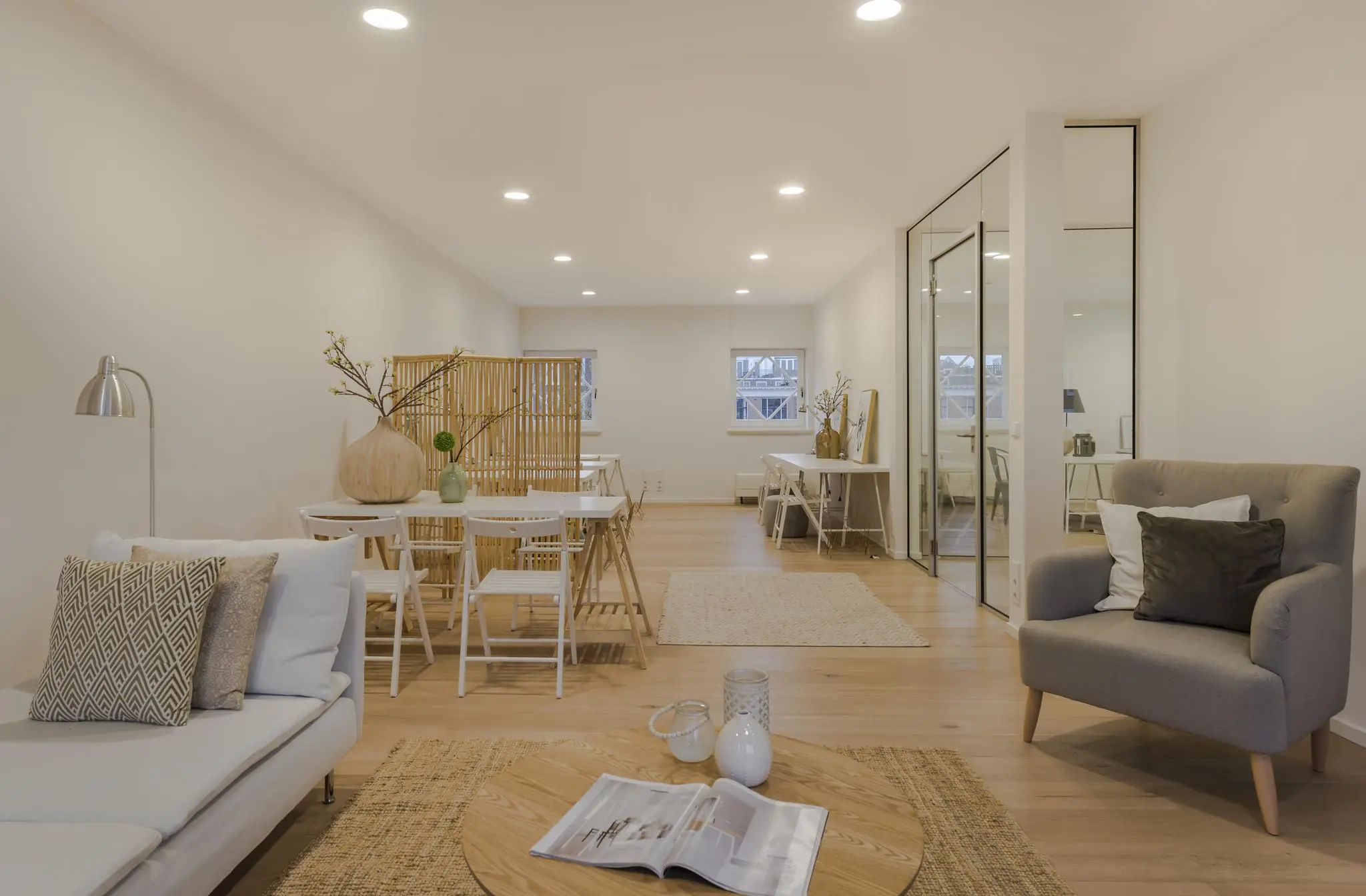 Modern ingerichte woonkamer en eetruimte met houten vloer, neutrale tinten en minimalistisch Scandinavisch design aan het Concertgebouwplein.