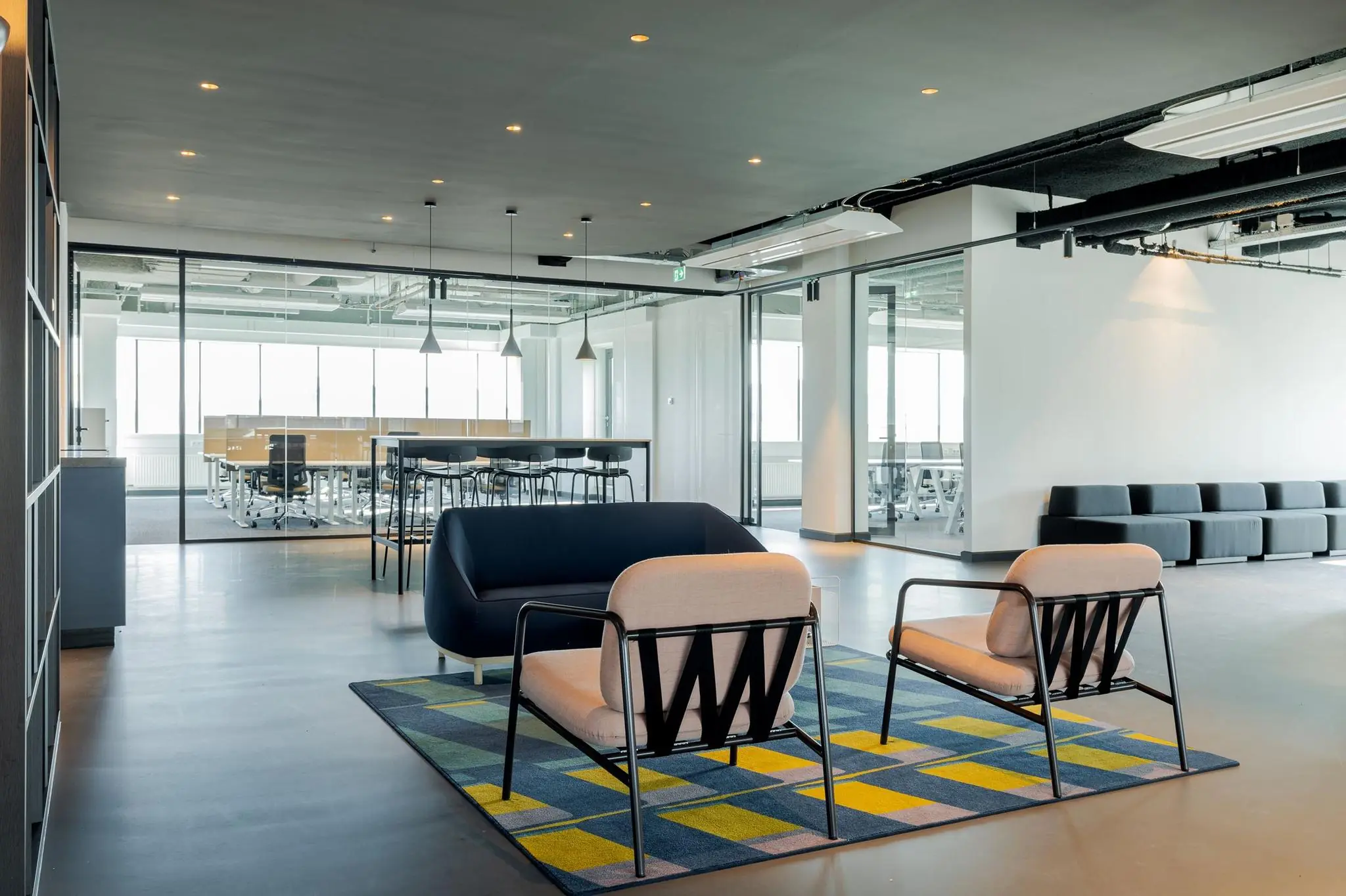 Moderne kantoorruimte aan het Weena met een zithoek, glazen vergaderruimtes en strak interieurdesign.