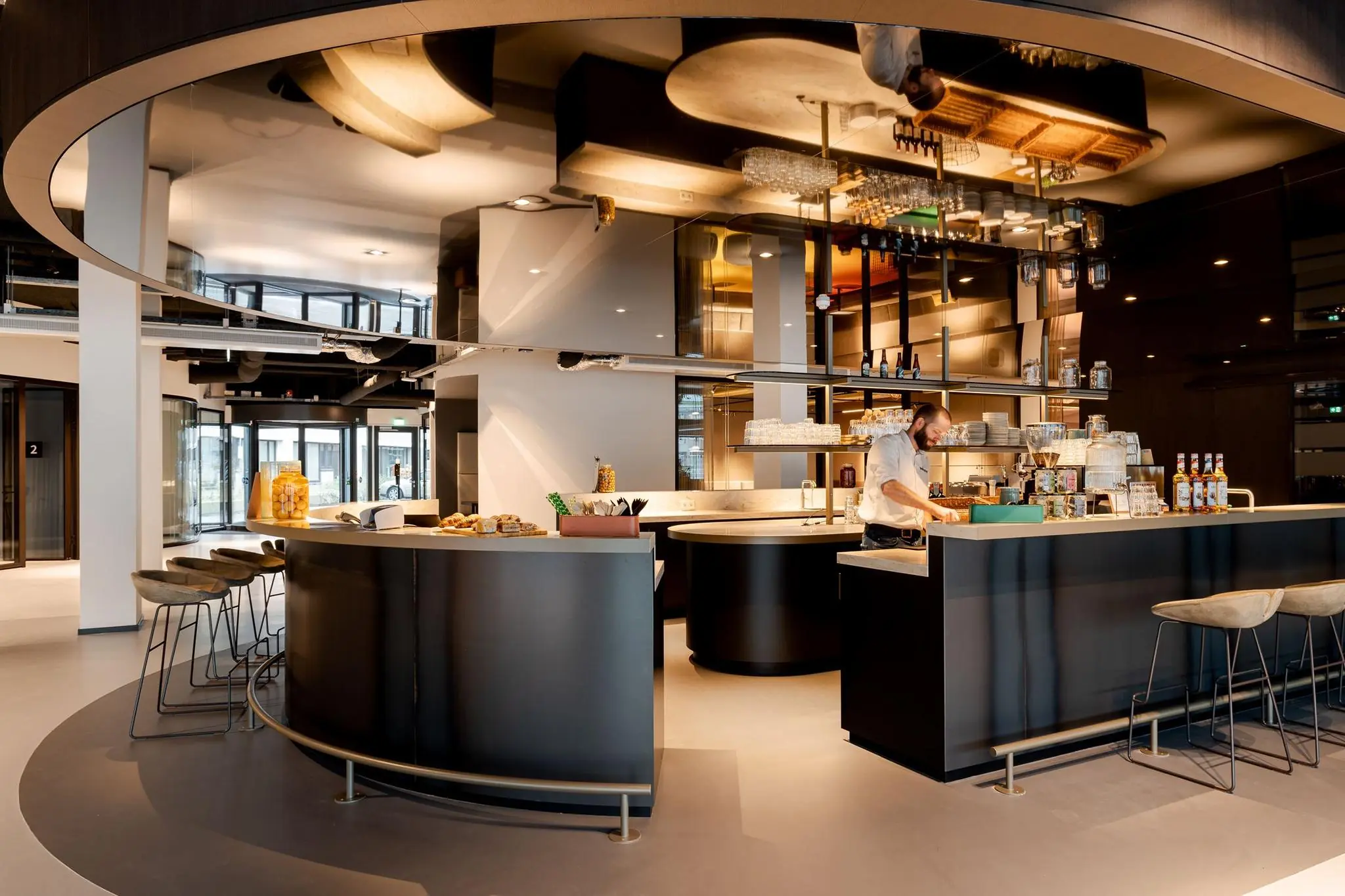 Moderne koffiebar met ronde balie en barista in een stijlvol interieur aan het Weena.