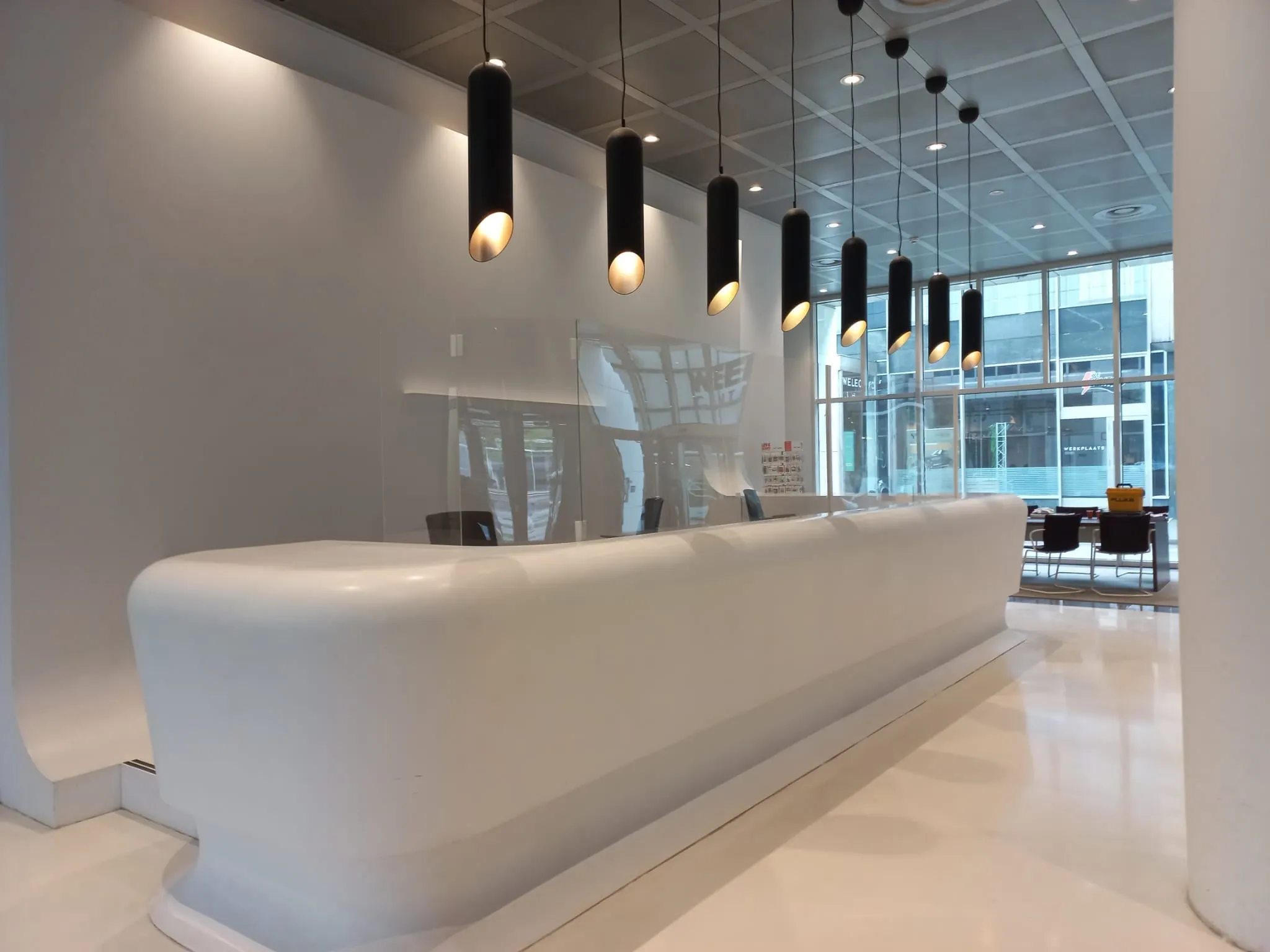 Moderne, minimalistische receptiebalie in een strak vormgegeven kantoorlobby aan het Weena in Rotterdam.