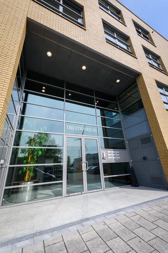 Ingang van het kantoorgebouw Tri Colore III in Capelle aan den IJssel met glazen gevel en dubbele deur.