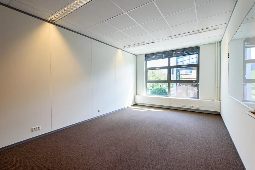 Licht en leeg kantoor op de tweede etage van gebouw Tricolore in Capelle aan den IJssel met groot raam en systeemplafond.