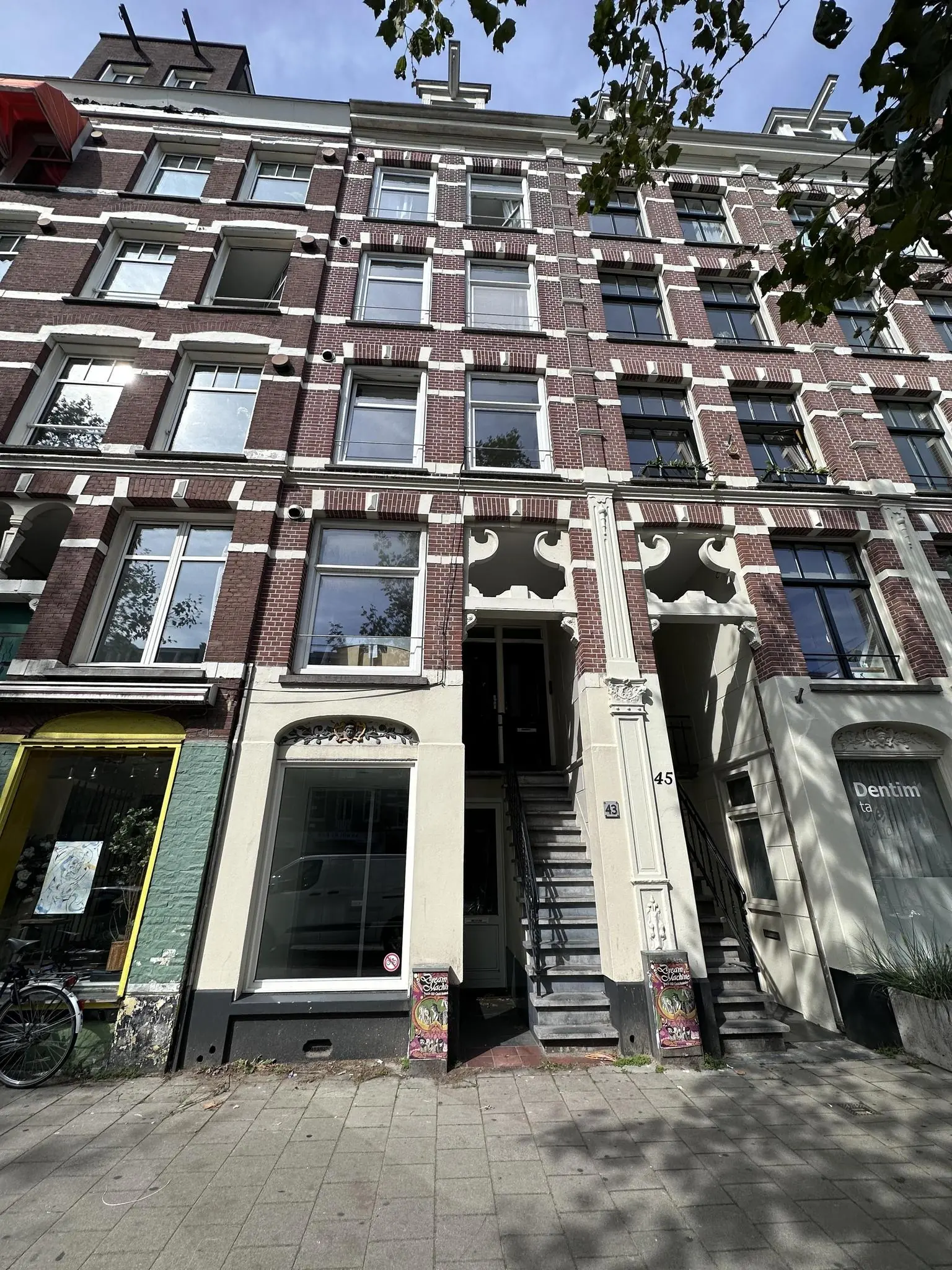 Voorgevel van een klassiek Amsterdams pand aan de Ceintuurbaan met bakstenen gevel, witte accenten en een trap naar de ingang.