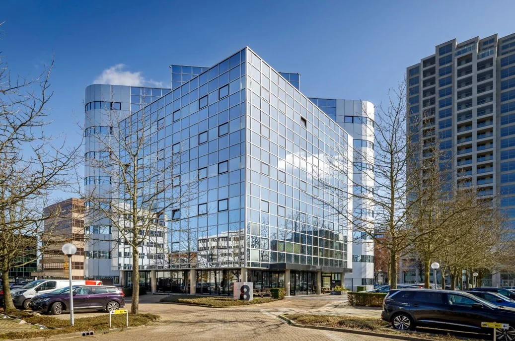Modern kantoorgebouw met een gevel van spiegelglas aan de Hogehilweg in Amsterdam.