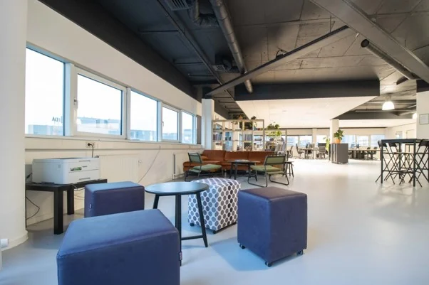 Moderne, open kantoorruimte aan de Hogehilweg met loungezitplekken, werkplekken en veel natuurlijk licht.