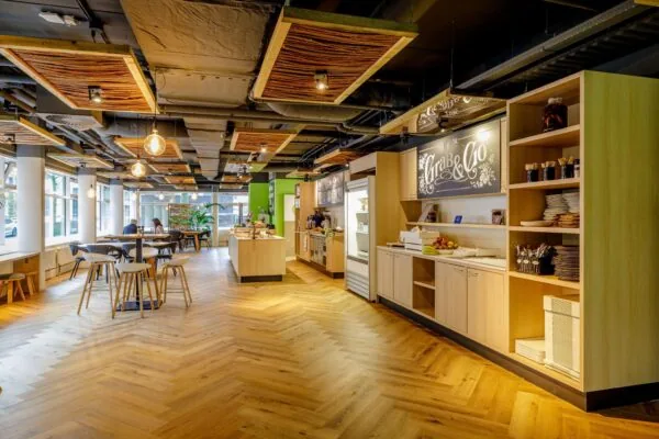 Modern ingerichte bedrijfskantine aan de Hullenbergweg met een zelfbedieningsgedeelte en zitplaatsen bij het raam.