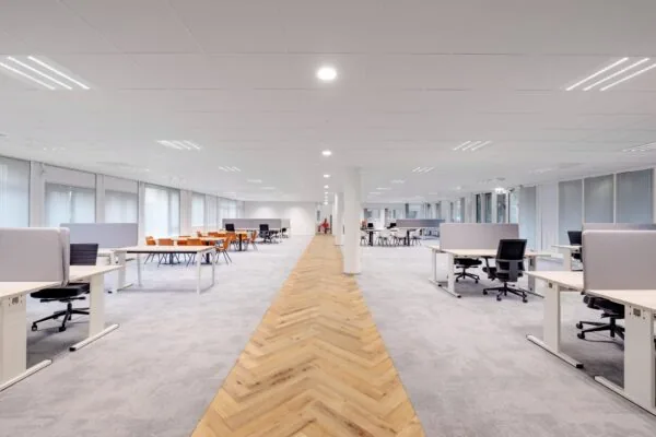 Licht en modern ingericht kantoorpand aan de Hullenbergweg met open werkplekken en vergadertafels.