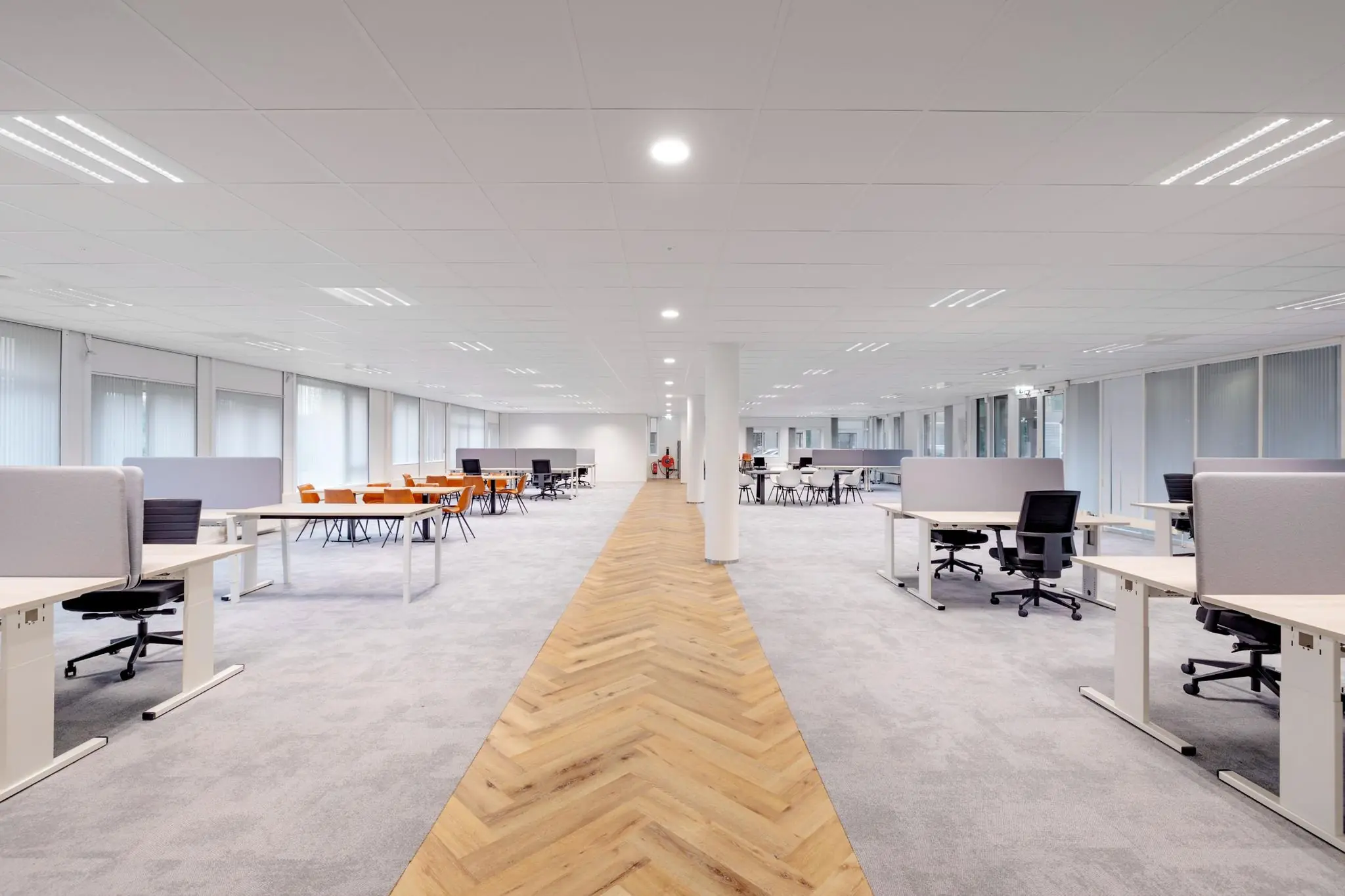 Licht en modern ingericht kantoorpand aan de Hullenbergweg met open werkplekken en vergadertafels.