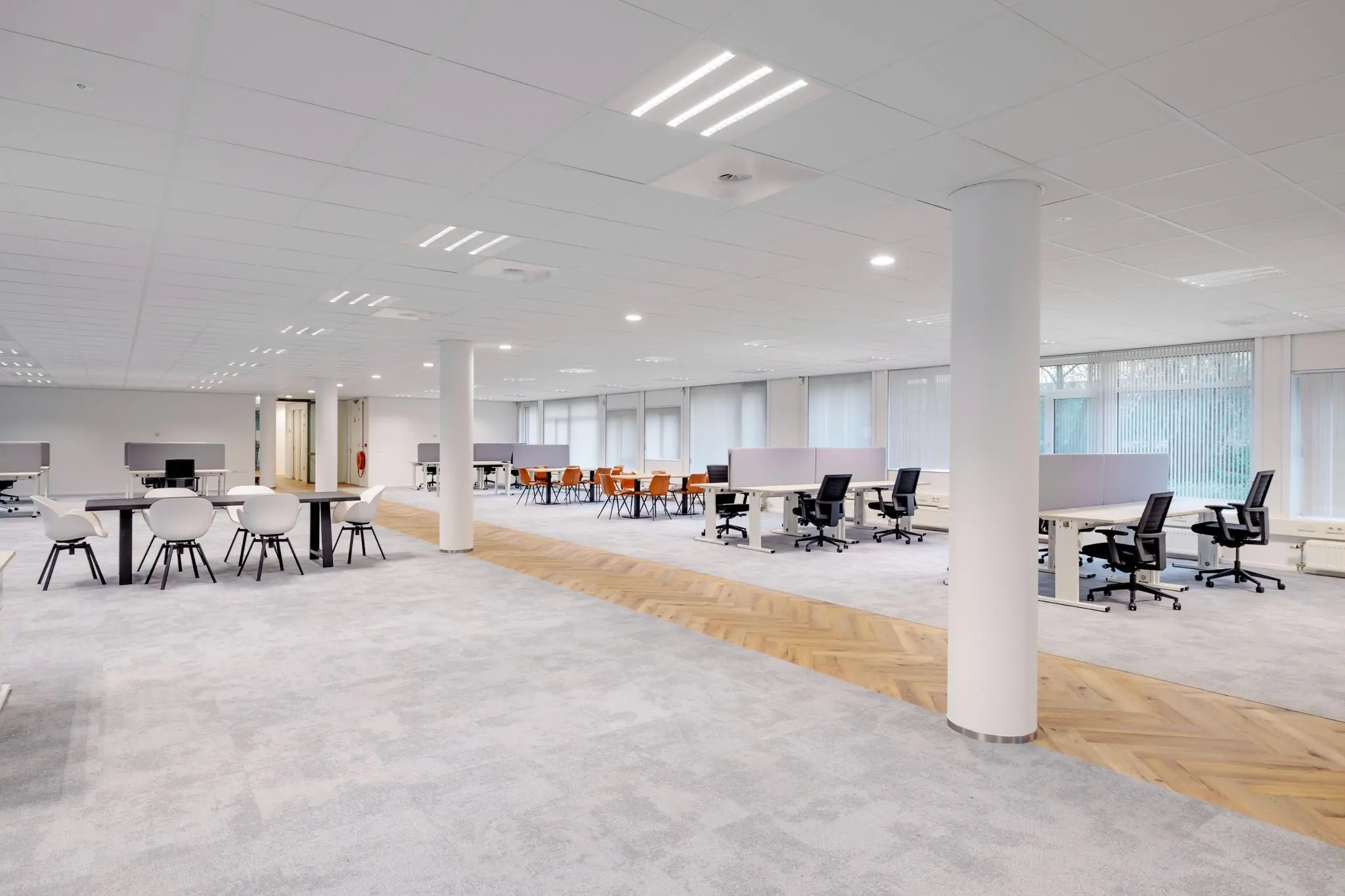 Ruim en modern kantoorpand aan de Hullenbergweg met open werkplekken, vergadertafels en grote raampartijen.