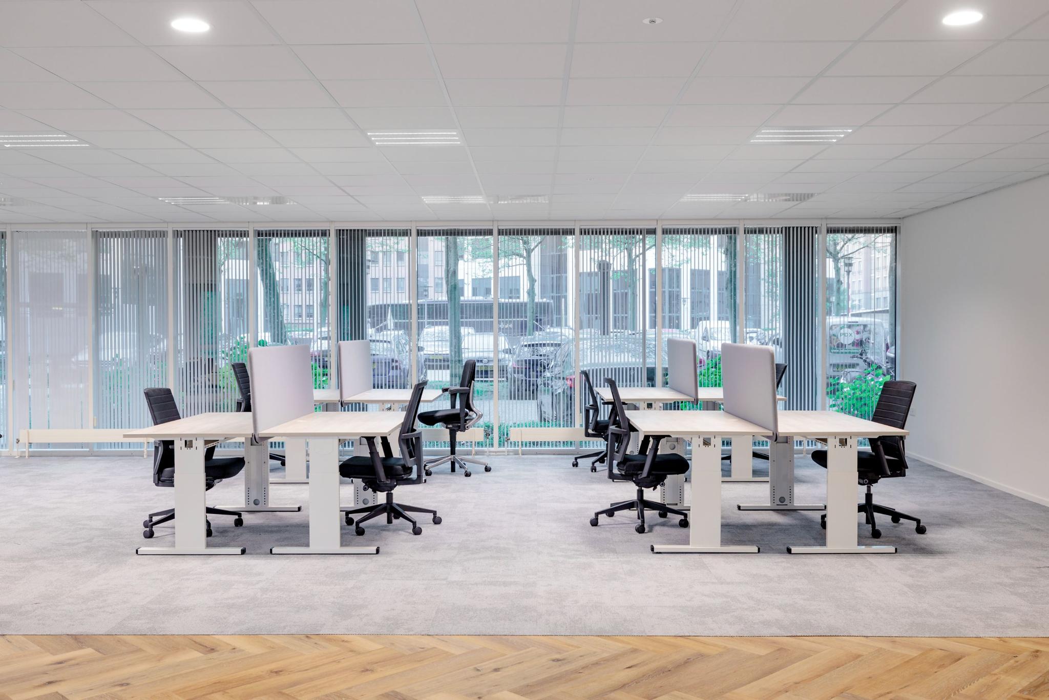 Moderne en lichte kantoortuin aan de Hullenbergweg met verstelbare bureaus en ergonomische bureaustoelen.