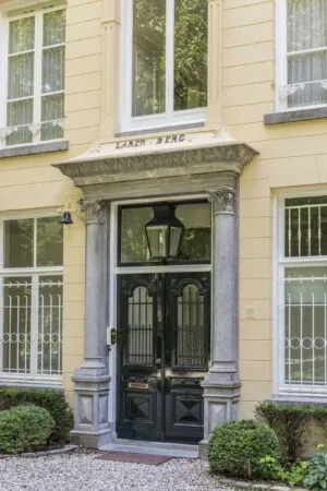 Voordeur van herenhuis 'Larenberg' aan de Naarderstraat met klassieke omlijsting en sierlijke details.