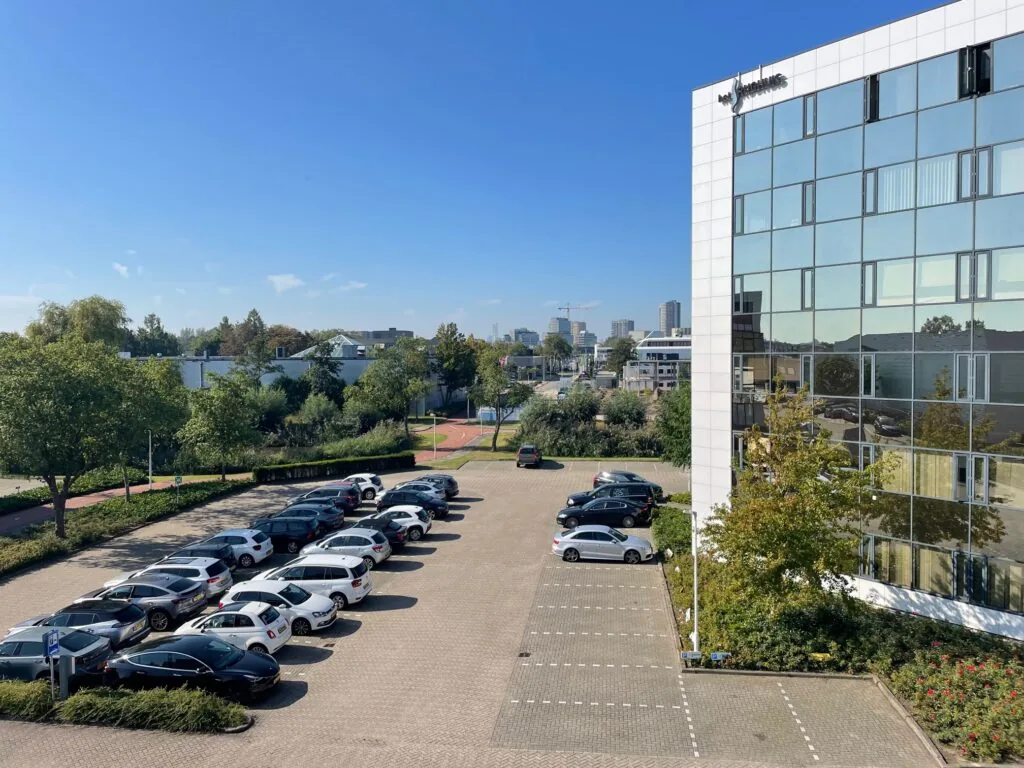 Kantoorgebouw aan de Cypresbaan met aangrenzende parkeergarage op een zonnige dag.