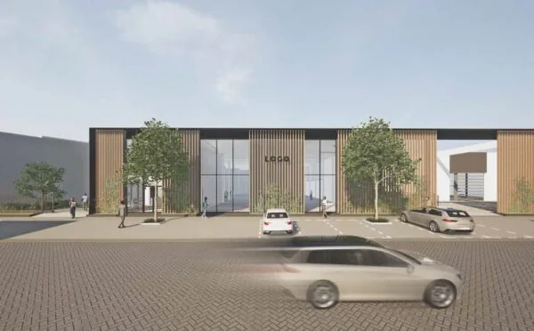 Moderne bedrijfs- of kantooromgeving aan de Strickledeweg met houten gevelbekleding, grote ramen en geparkeerde auto's op de voorgrond.