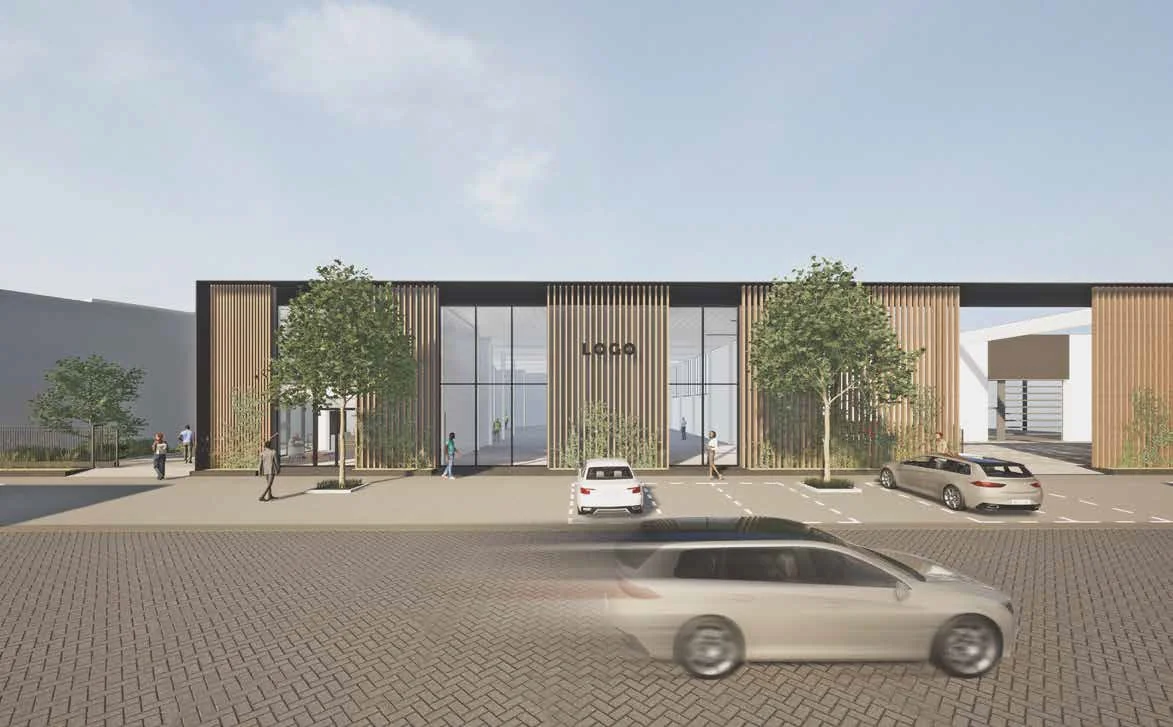 Moderne bedrijfs- of kantooromgeving aan de Strickledeweg met houten gevelbekleding, grote ramen en geparkeerde auto's op de voorgrond.