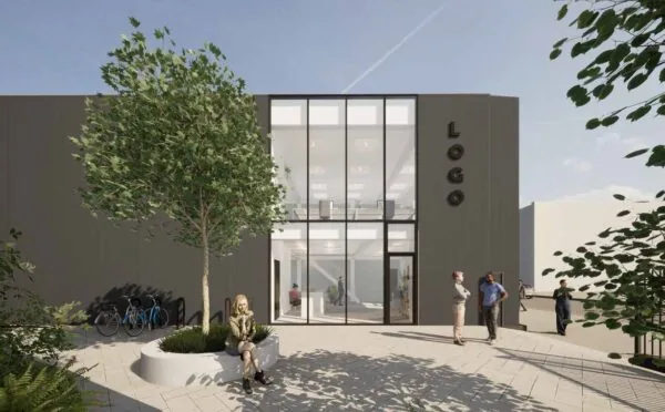 Moderne kantoorgevel aan de Strickledeweg met grote glazen ramen, een boom in een plantsoen en mensen op het plein.