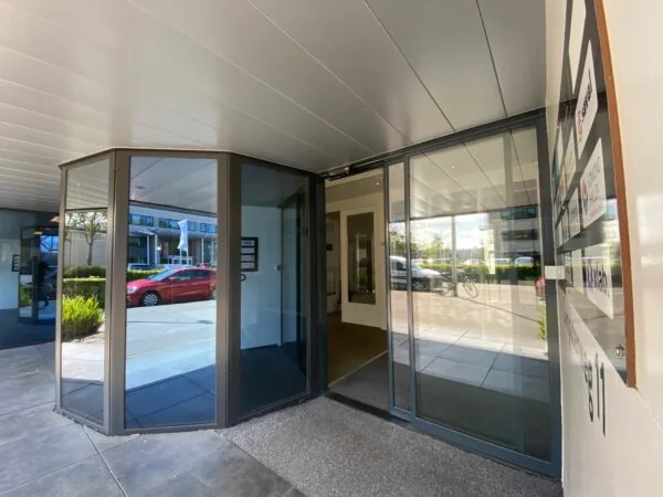 Ingang van een kantoorpand aan de Computerweg met glazen draaideur en bedrijvenbord.