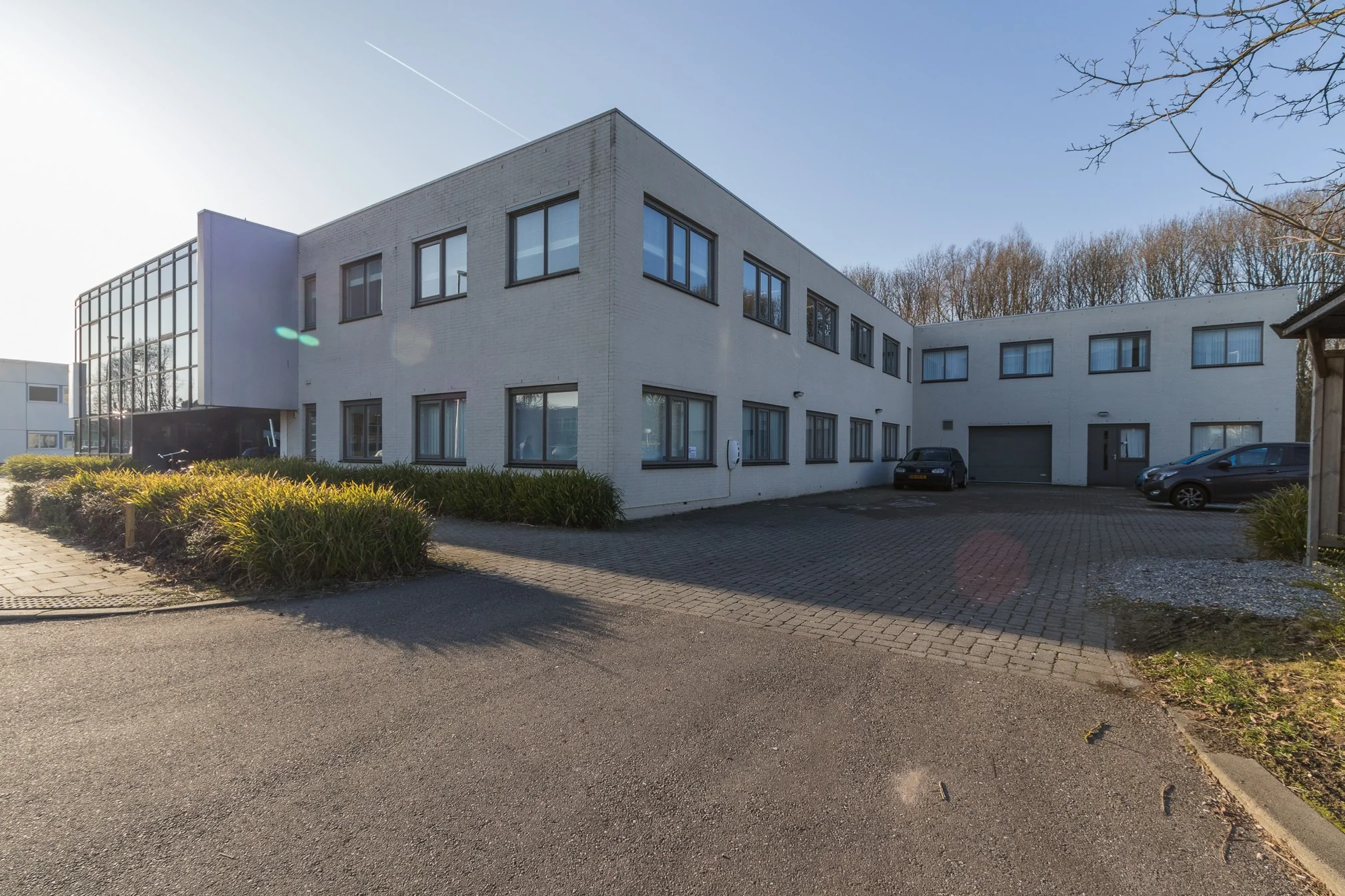 Wit kantoorgebouw aan de Computerweg met parkeerplaatsen en omliggend groen.