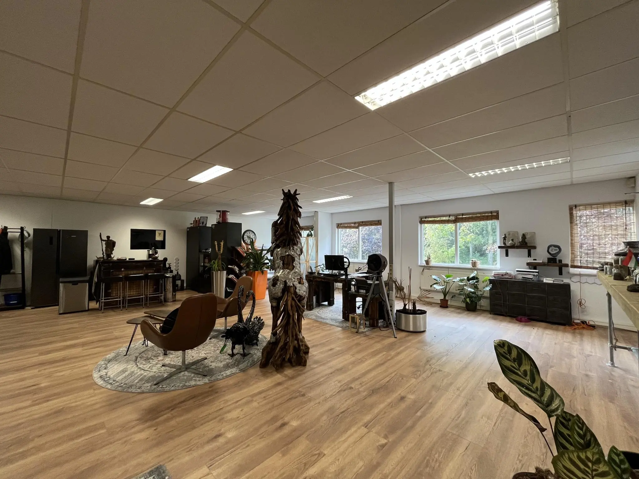 Ruim en licht kantoor aan de Computerweg met houten vloer, moderne werkplekken en veel planten.
